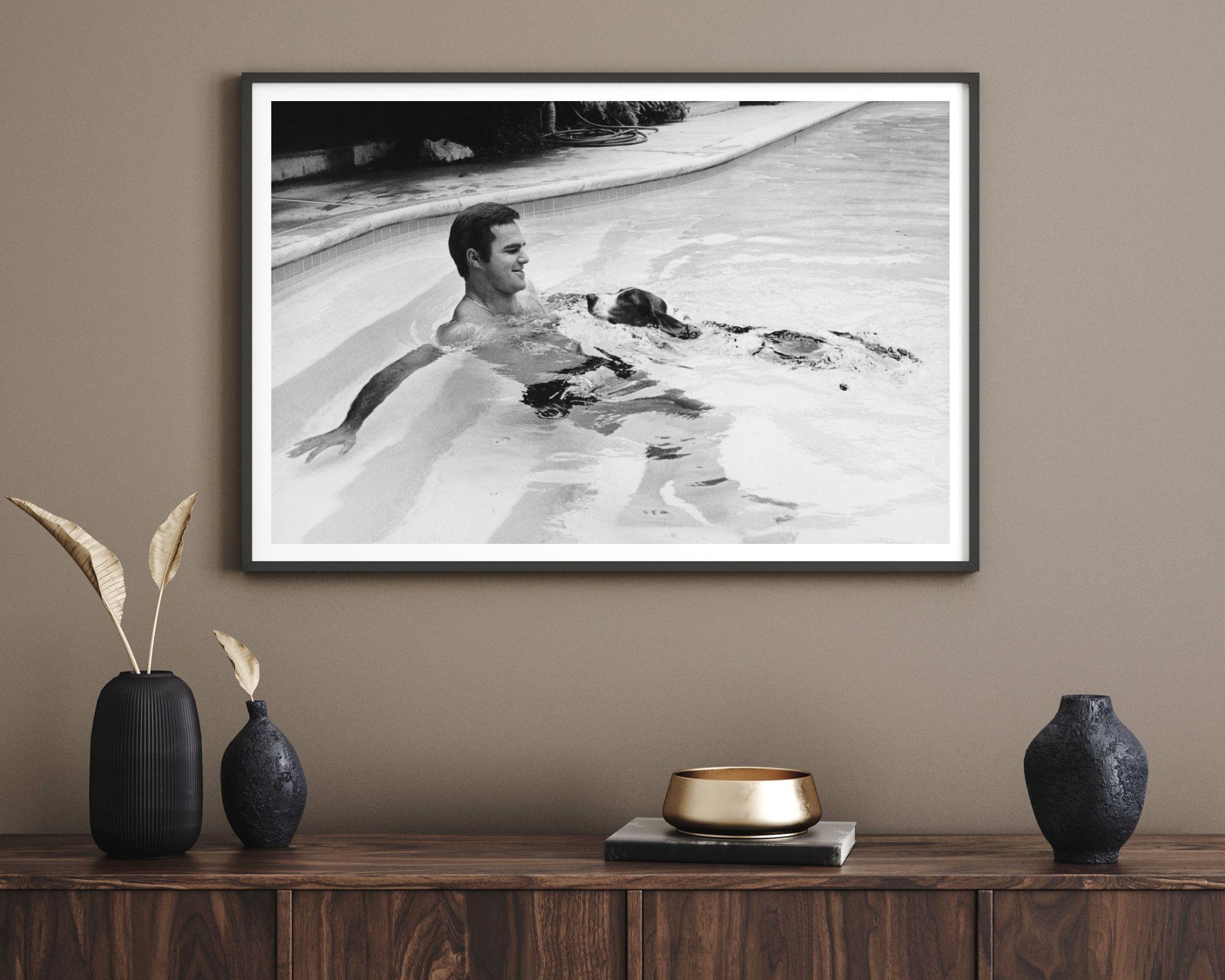 Burt Reynolds schwimmt mit seinem Basset-Hunde – Photograph von Unknown