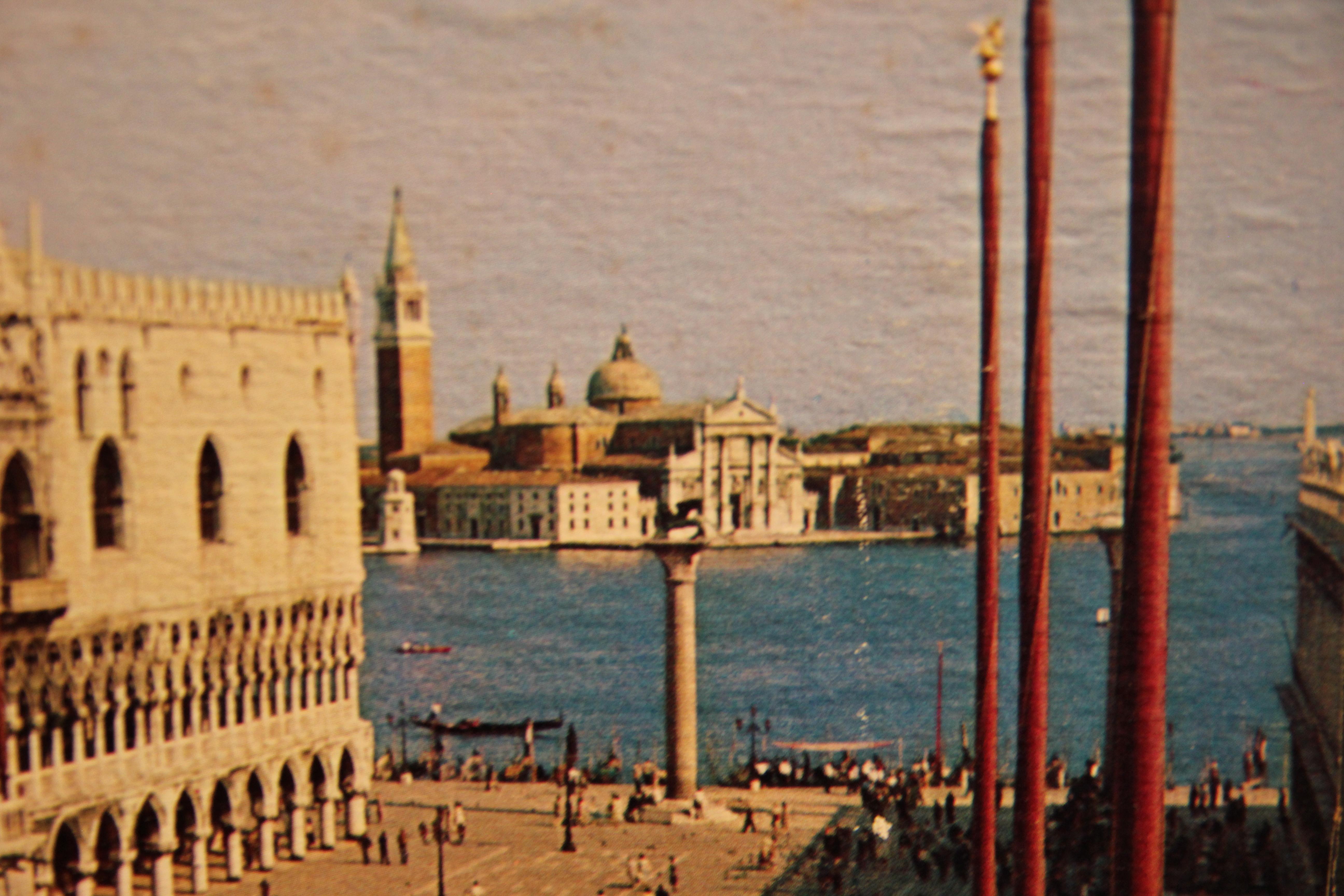 Colored photograph of the St. Marks Square in Italy. The photograph is matted to a thick board to protect against bending. The photograph is not framed.