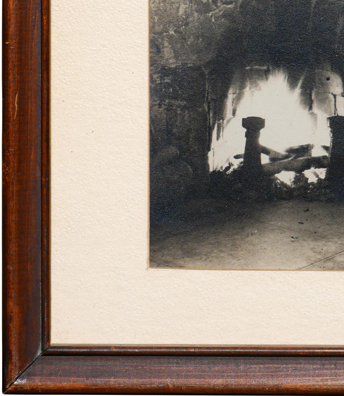 Fotografia di still life in bianco e nero di un caminetto. Il pezzo documenta anche i vari oggetti utilizzati per decorare il focolare, tra cui cesti intrecciati e vasi di terra. Firmato 