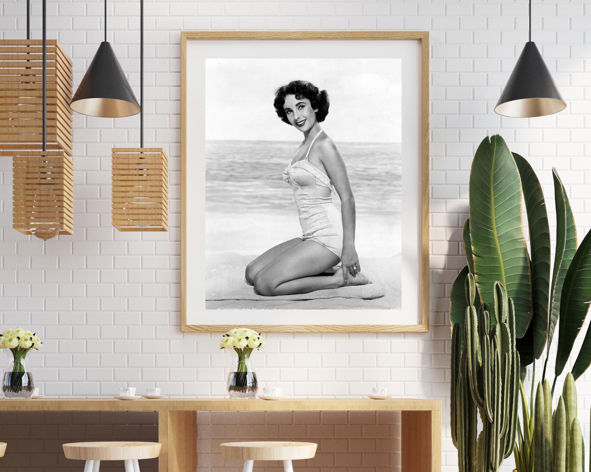 Elizabeth Taylor Kneeling on Beach - Contemporary Photograph by Unknown