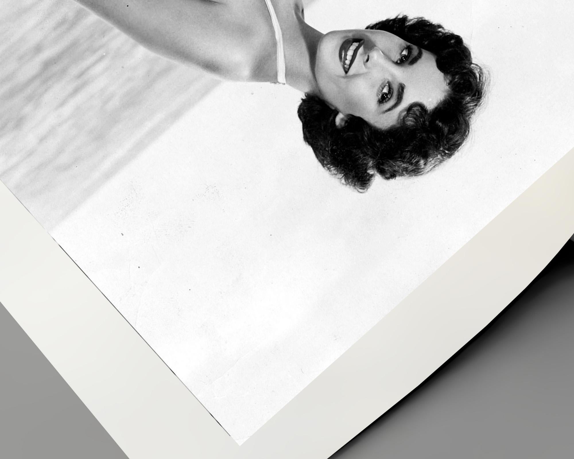 Elizabeth Taylor Kneeling on Beach - Gray Portrait Photograph by Unknown