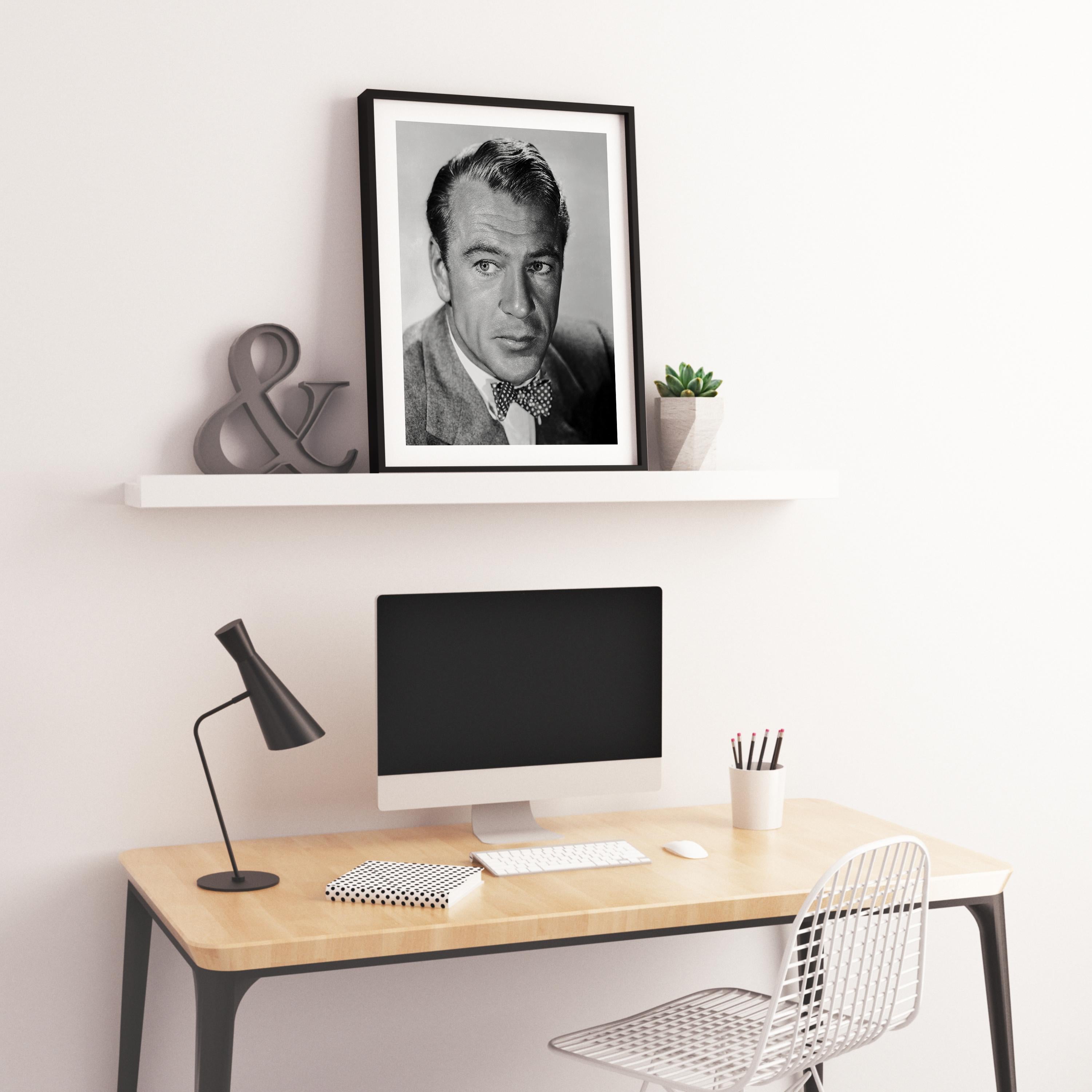 This black and white portrait features American film actor Gary Cooper. Best known for his natural, authentic, and understated acting style and screen performances, his career spanned over thirty years and included leading roles in eighty-four