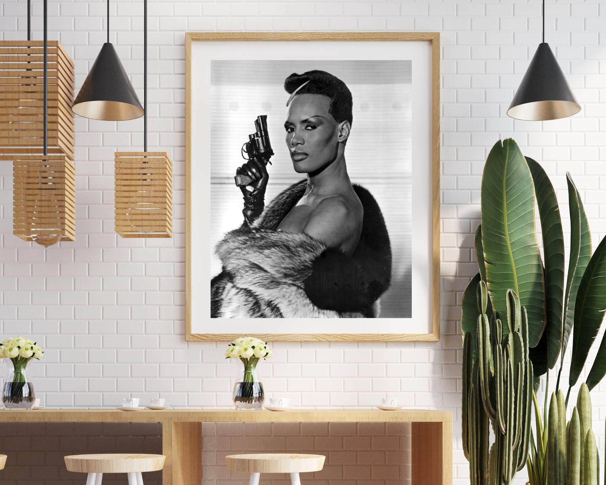 Grace Jones Holding Pistol - Photograph by Unknown
