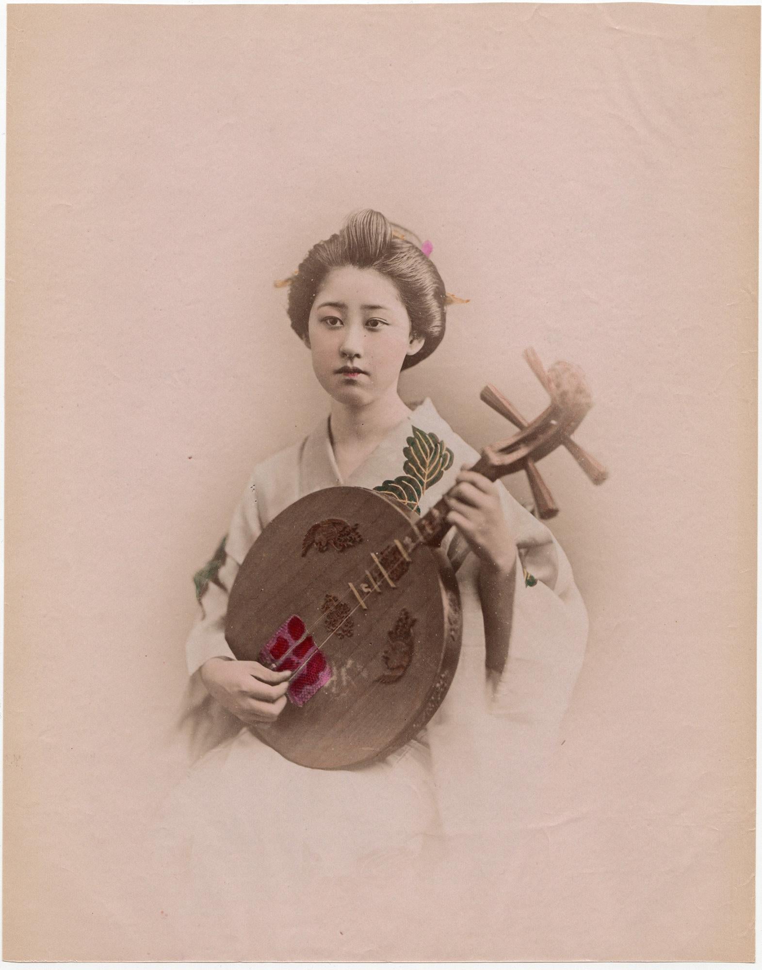 Japan – A geisha playing the gekkin - Hand-colored Meiji Period photograph