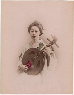 Antique Japan – A geisha playing the gekkin - Hand-colored Meiji Period photograph