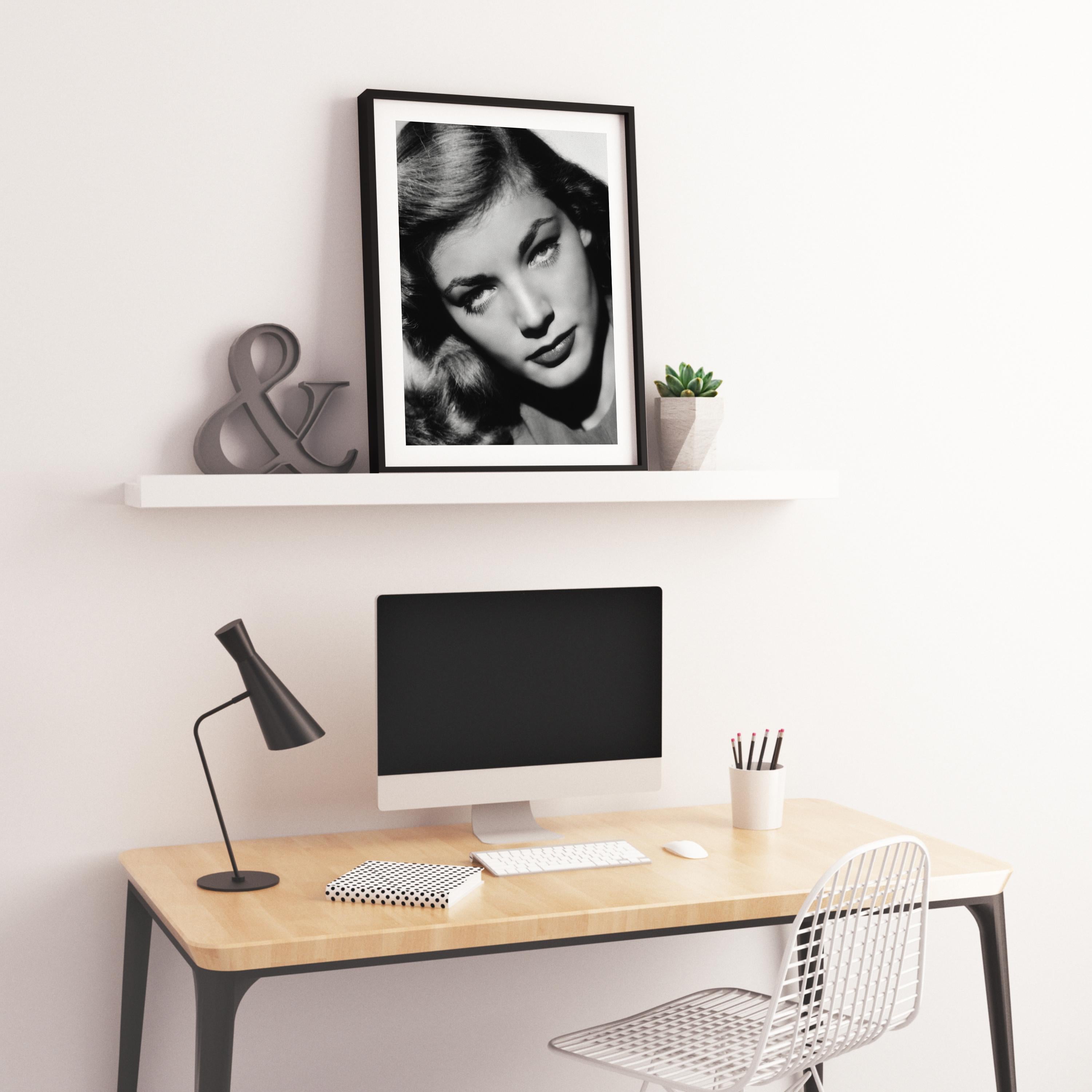 This candid black and white image features Lauren Bacall posed seductively in the studio, a closeup portrait.

Lauren Bacall was an American actress known for her distinctive voice and sultry looks. She was named the 20th greatest female star of