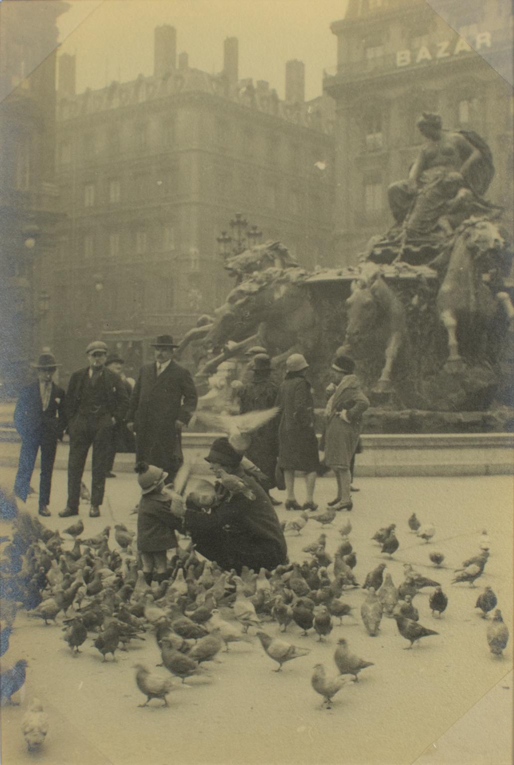 A unique original silver gelatin black and white photography, Place des Renaux in Lyon, France, March 1927. 
The photograph presents a view of Place des Renaux in Lyon, France, with a woman and child feeding pigeons, dated March 9,
