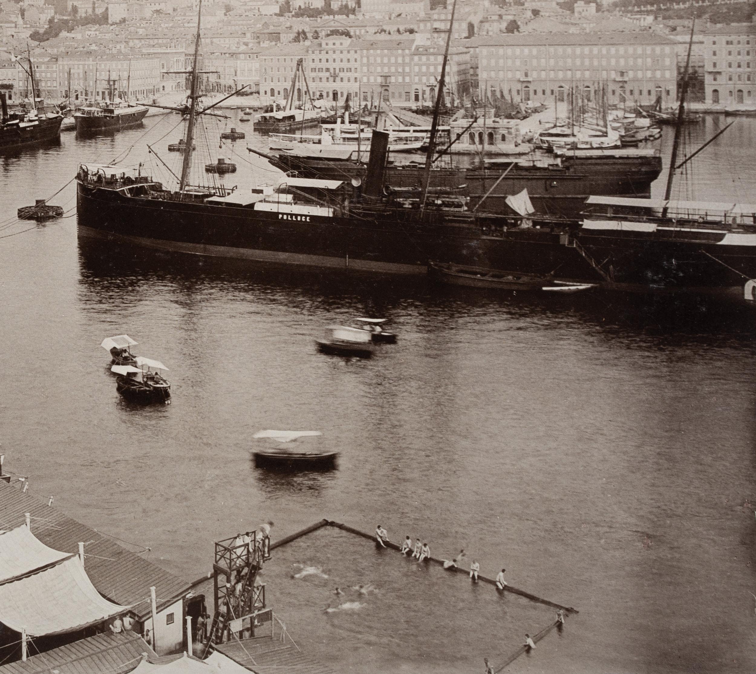 Stengel & Co. (19th century): Elevated view from the lighthouse over the port of Trieste with large ships and fenced-off outdoor pool with bathers, c. 1900, albumen paper print

Technique: albumen paper print, mounted on Cardboard

Stamp: Blank