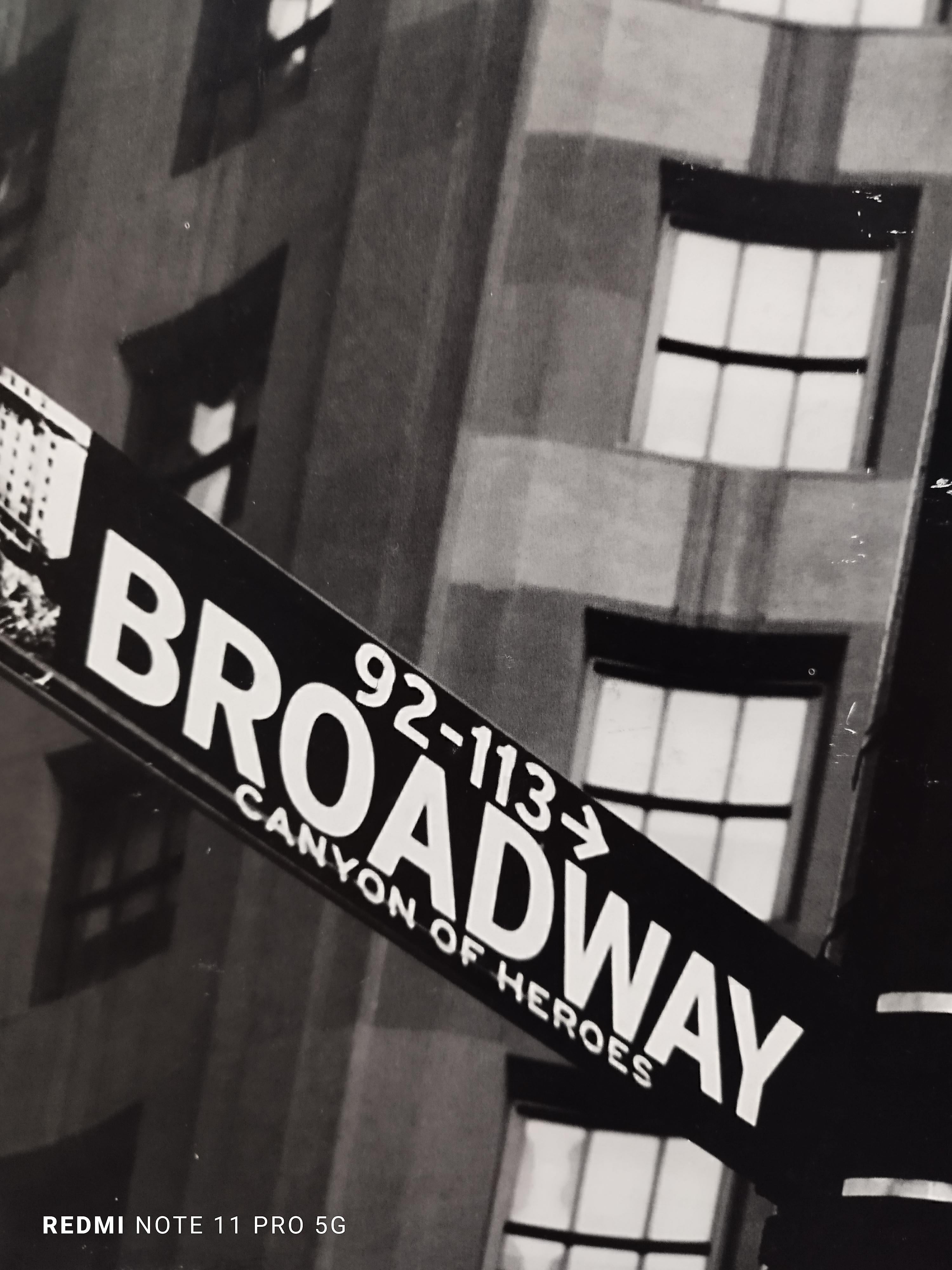 Iconic black and white photograph on baryta paper of the intersection of Broadway and Wall Street.
