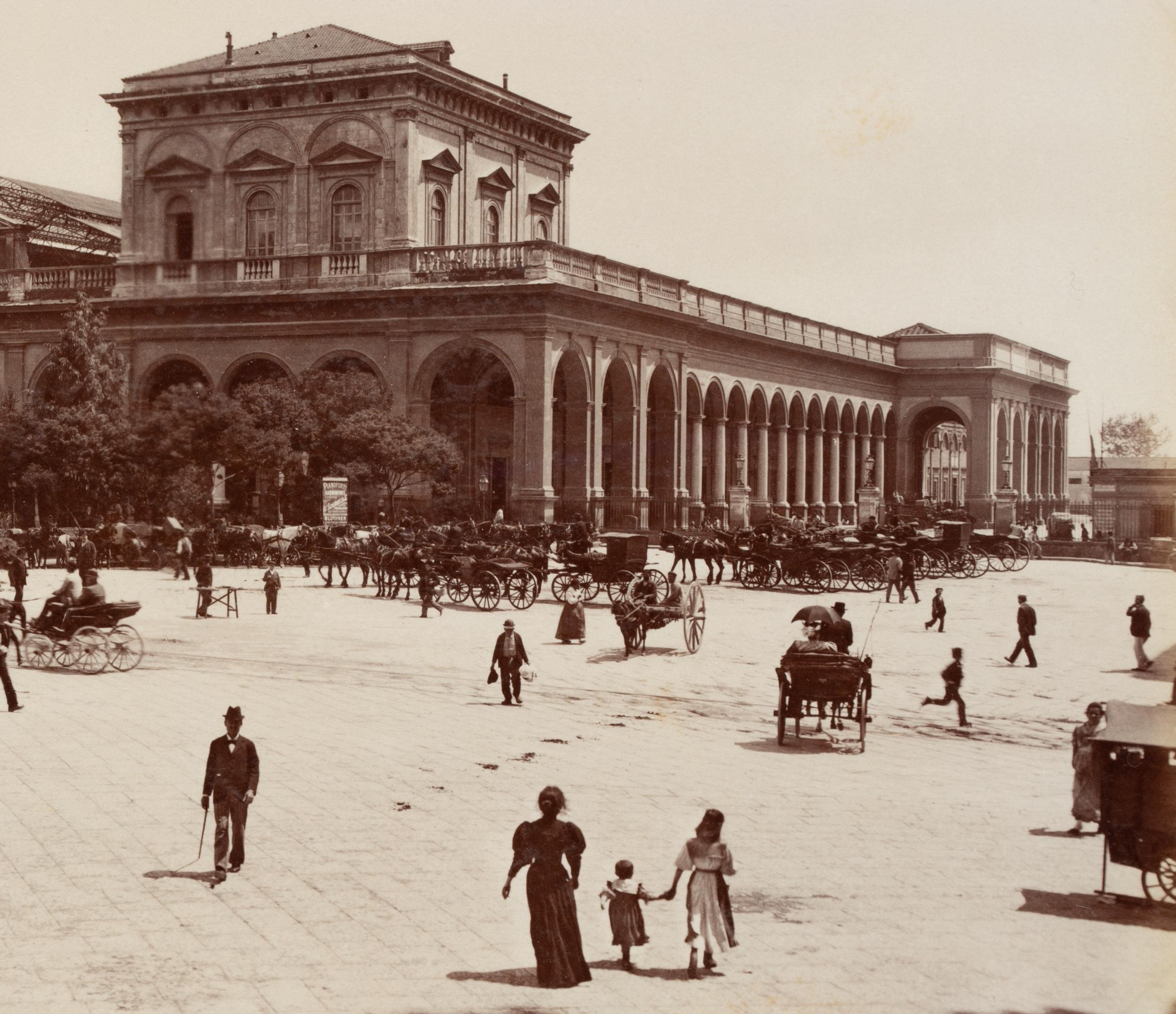 Fratelli Alinari (19th century): La Piazza della Stazione View over the busy square and the old reception building of Naples Central Station with carriages and passers-by, c. 1880, albumen paper print

Technique: albumen paper print

Inscription: