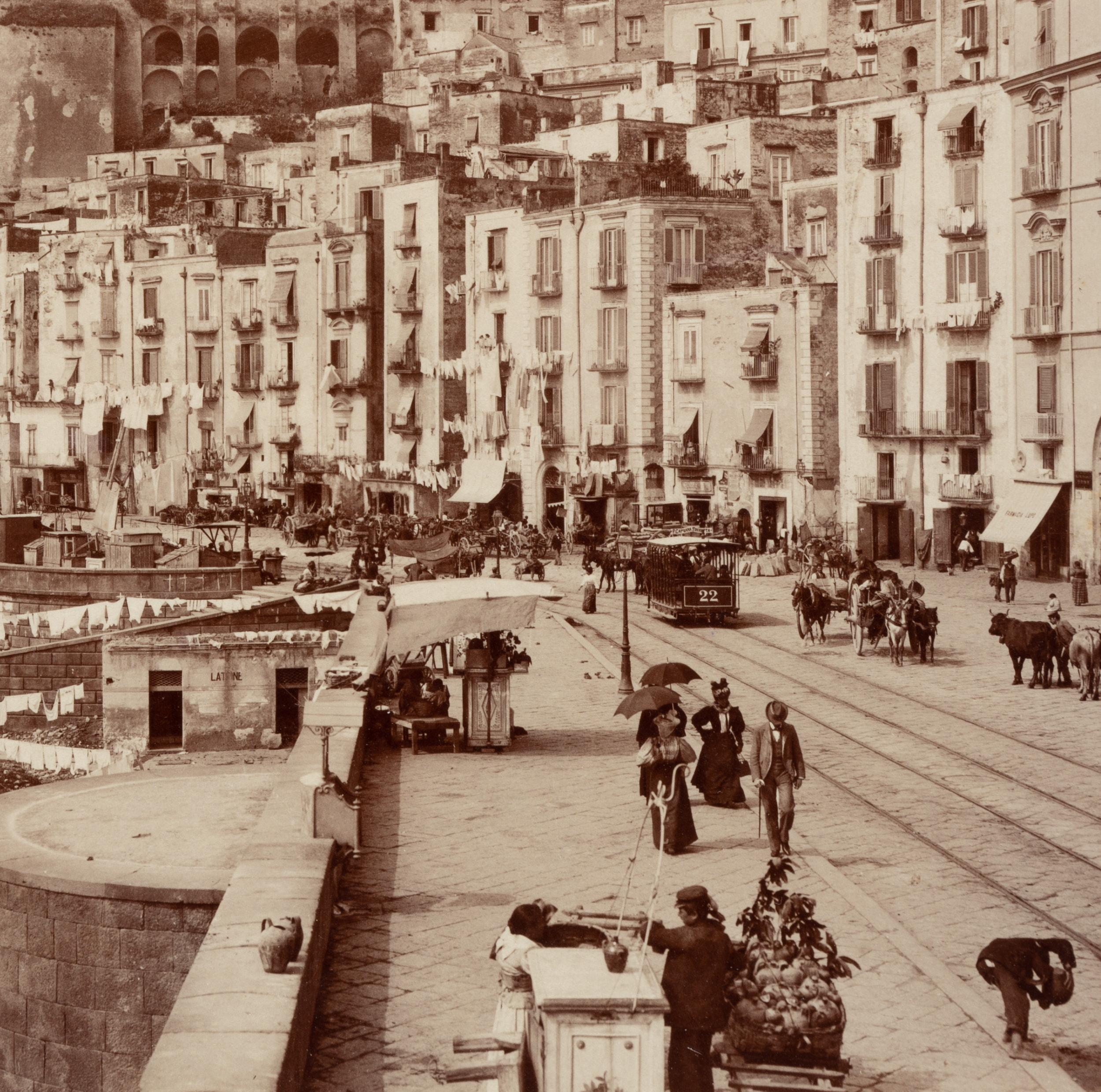 Fratelli Alinari (19th century): Lively street scene with passers-by, carriages and drying laundry on linen Strada di Santa Lucia, today Via Santa Lucia with view of the Pizzofalcone hill, Naples, c. 1880, albumen paper print

Technique: albumen