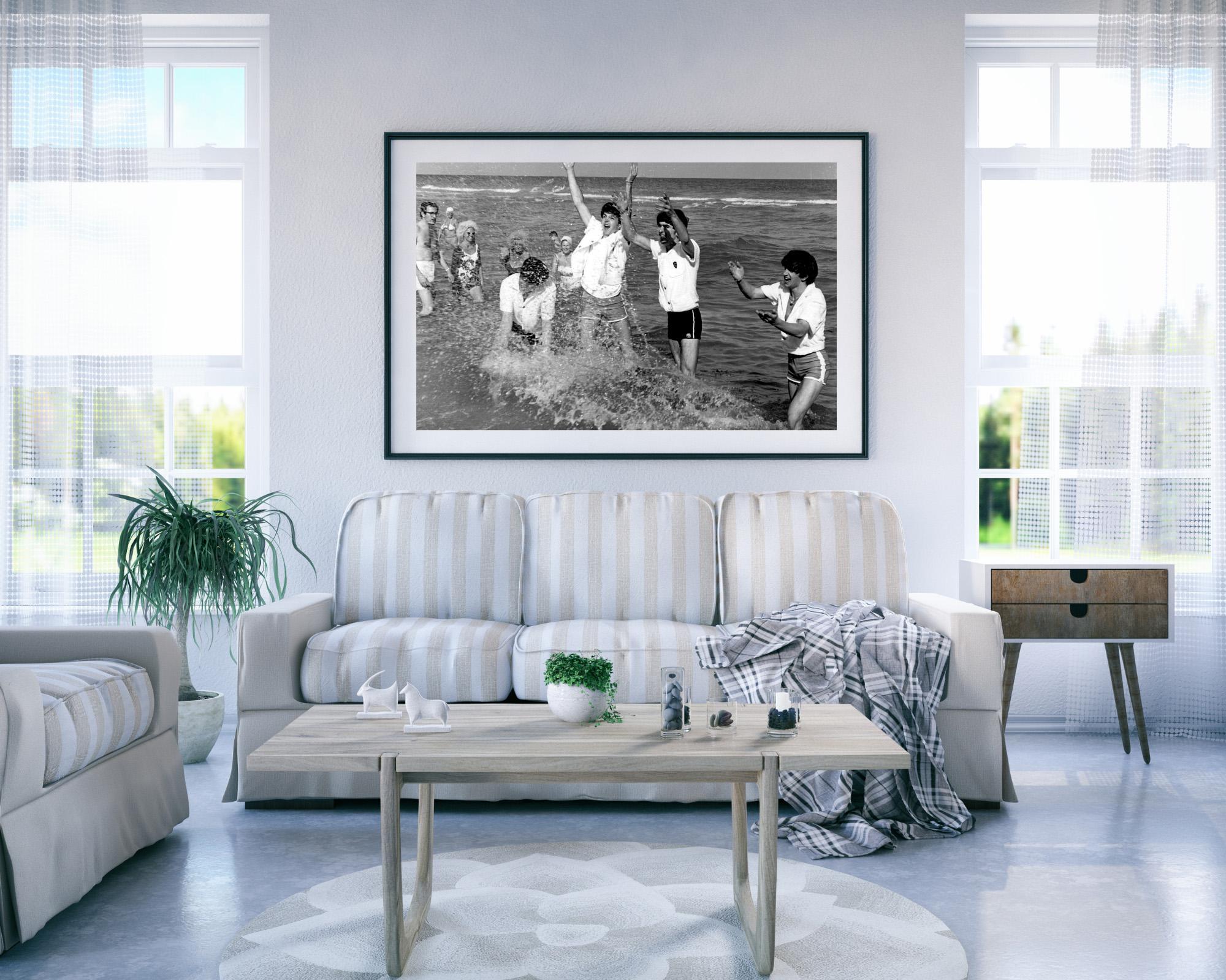 Cette photo en noir et blanc montre les Beatles, Paul McCartney, John Lennon, George Harrison et Ringo Starr s'éclaboussant dans la mer, vers 1964.

Les Beatles étaient un groupe de rock anglais formé à Liverpool, dont les compositions innovantes et