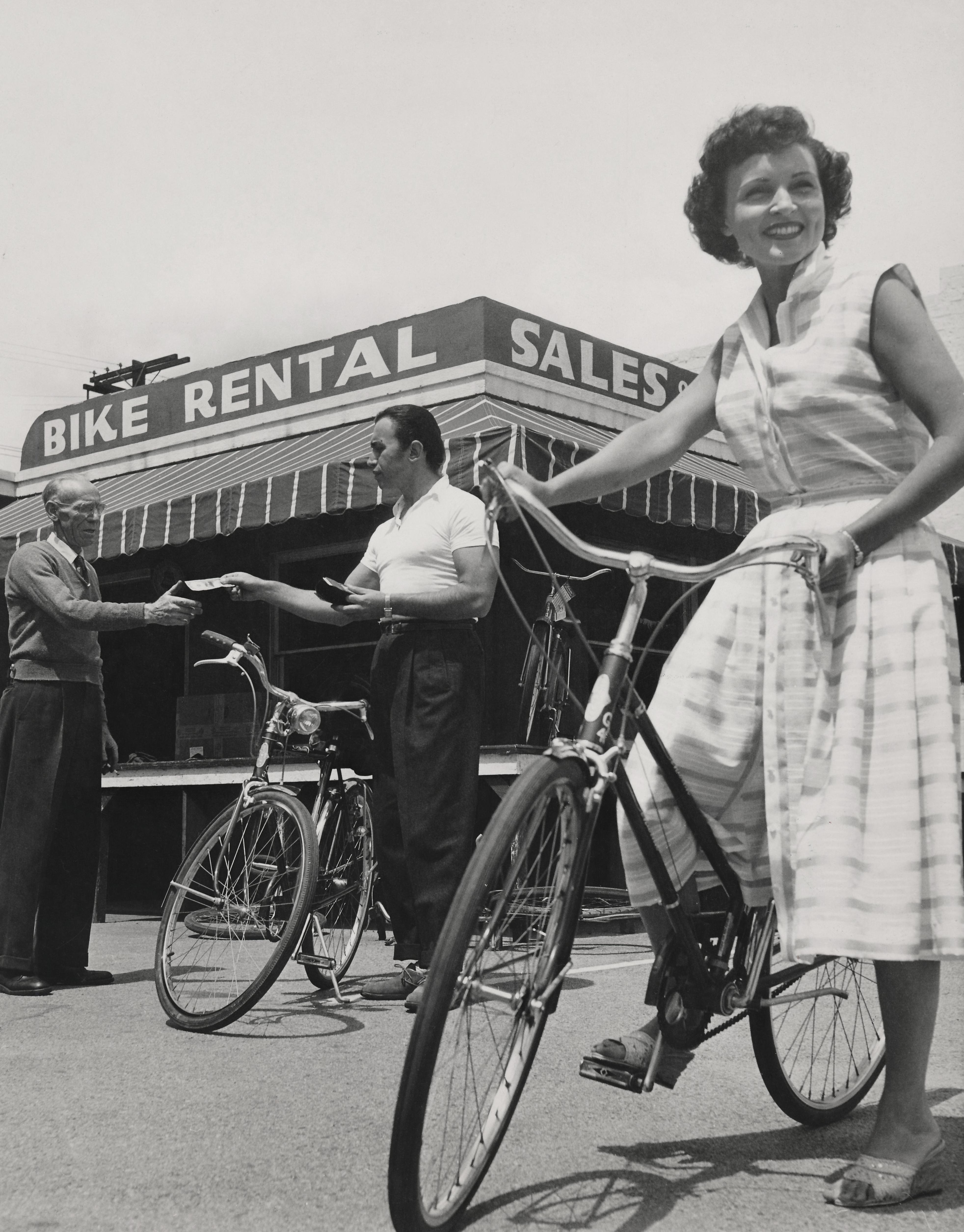 Unknown Black and White Photograph - Vintage Betty White at Bike Rental Stand Fine Art Print