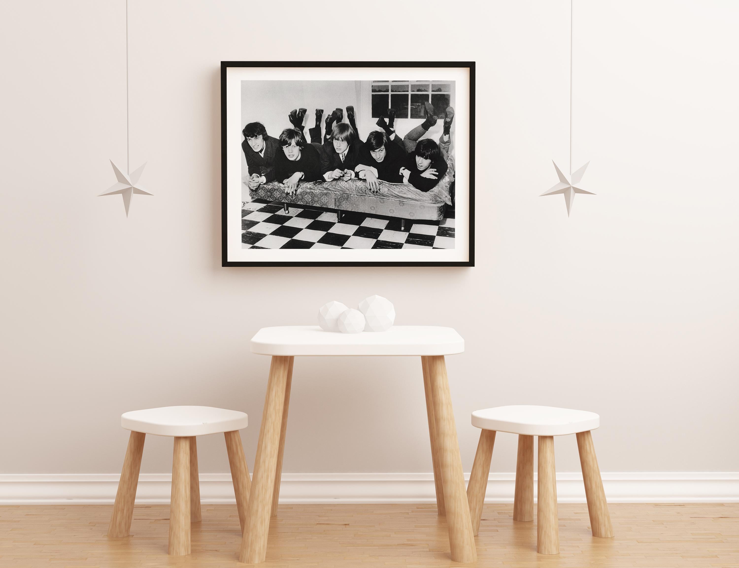 This candid black and white portrait features The Rolling Stones members in their younger years, posed lying on a mattress.

The Rolling Stones were at the forefront of the British Invasion of bands that became popular in the United States in 1964