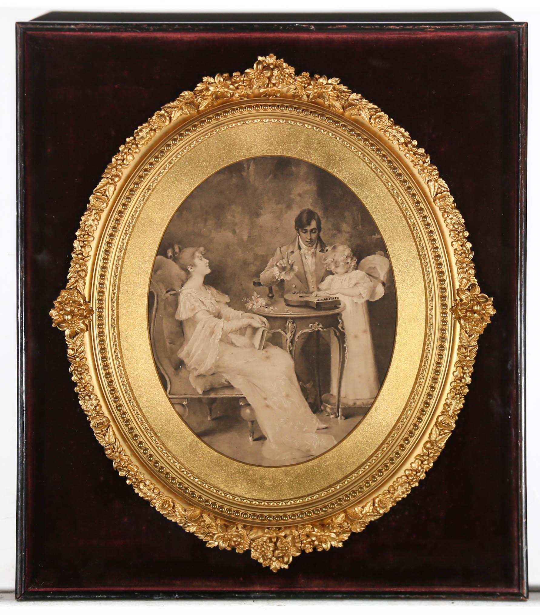 A charming mezzotint depicting a family gathered around a table. The father teaches a young child how to play a zither while the mother watches. Beautifully presented in a cabinet frame with ornate floral moulding to the inner oval gilt frame.