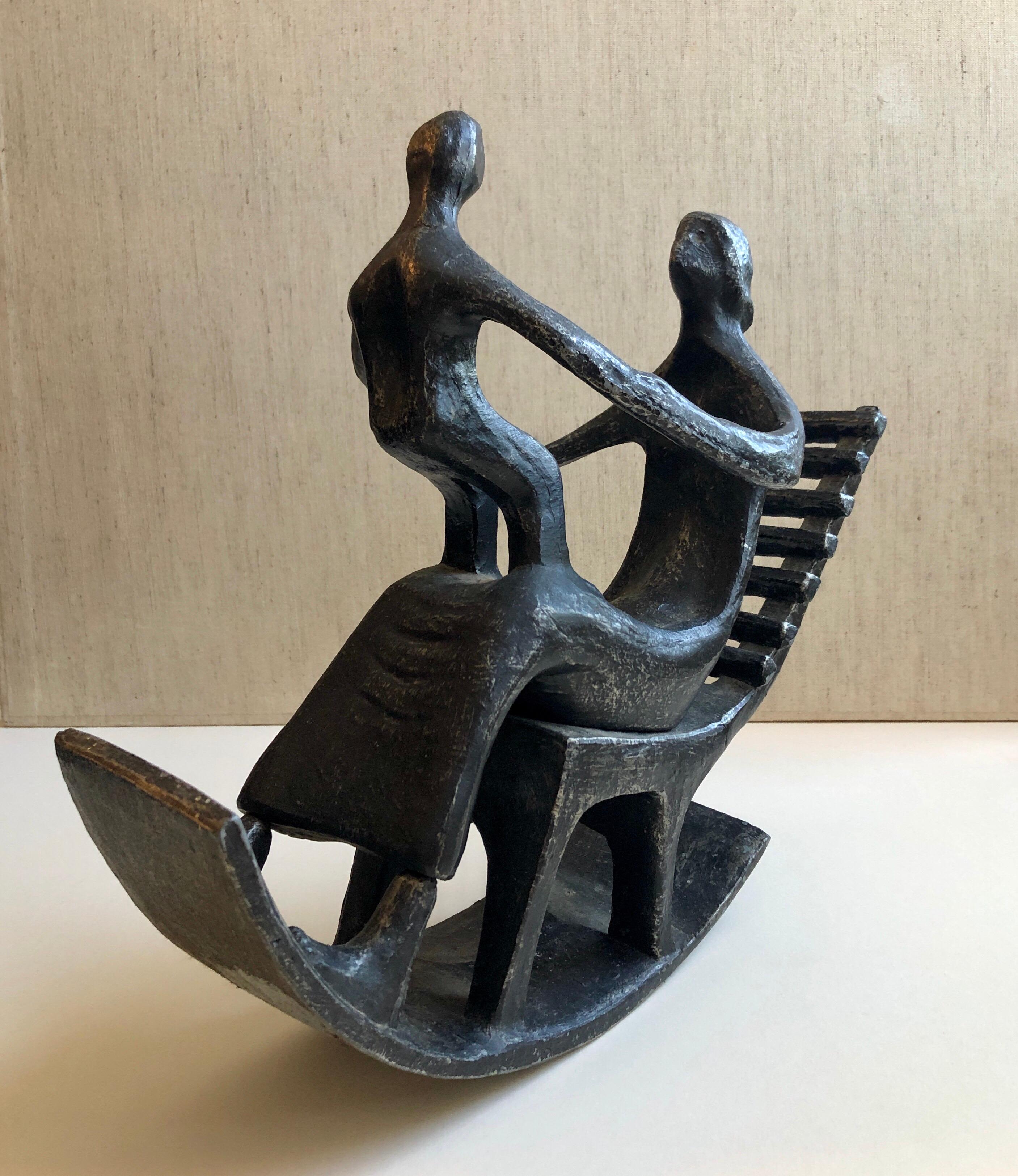 Il s'agit d'une sculpture en métal moulé représentant une femme et son enfant, une mère et son bébé dans un fauteuil à bascule. Il présente une patine sur un métal blanc. On ne sait pas s'il s'agit d'acier ou d'aluminium. C'est une pièce vintage