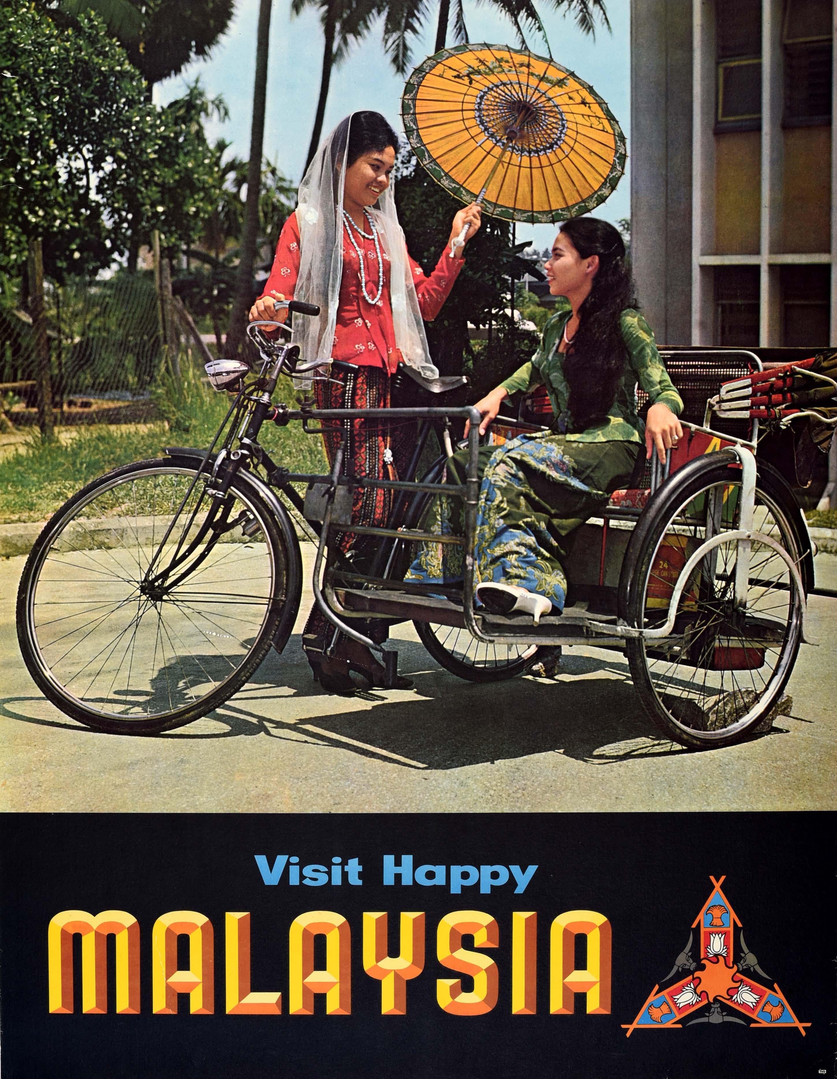 Original Vintage Asien Reiseplakat - Visit Happy Malaysia Fly there by Thai International - mit einem großen Foto von zwei lächelnden malaysischen Damen in traditionellen bunten Batikkleidern, eine Dame sitzt auf einer Fahrrad-Rikscha und die andere