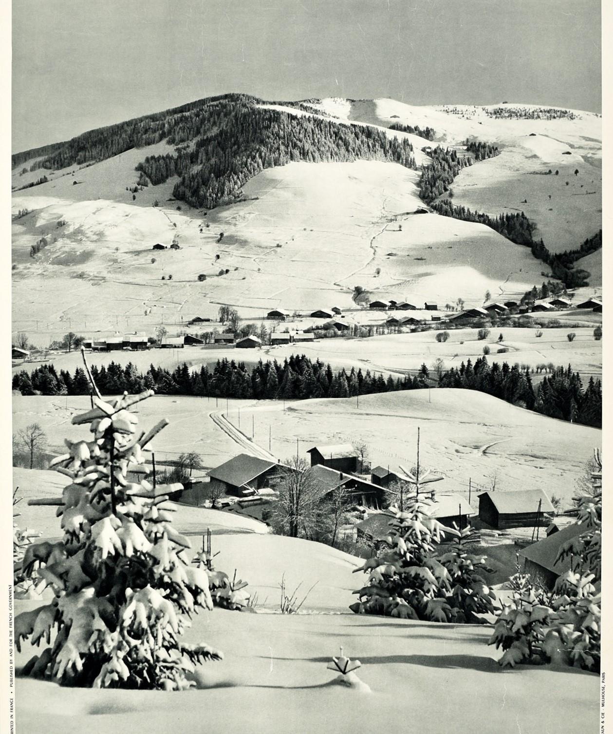 Original poster de voyage de ski vintage pour la France - Megeve Haute Savoie - présentant une vue scénique en noir et blanc d'arbres et de toits enneigés dans le village devant les montagnes avec le texte du titre en gras en dessous. La station de