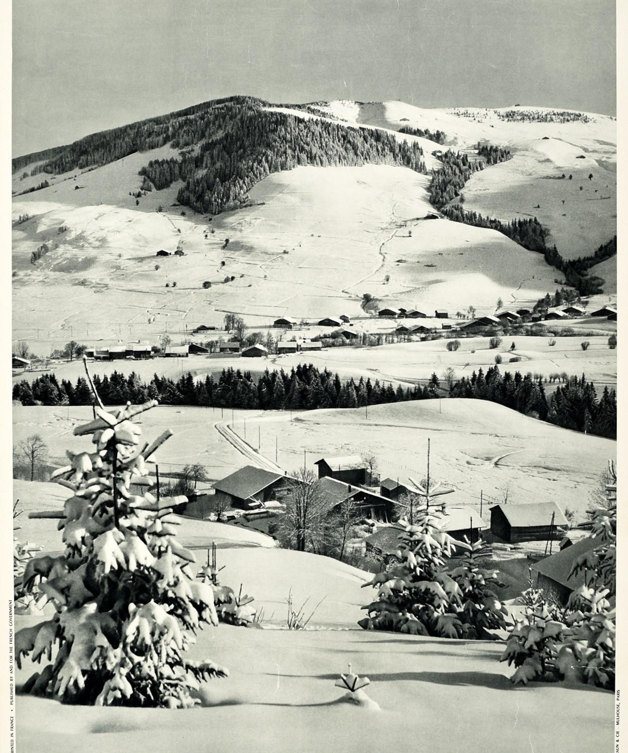 Original vintage ski travel poster for France - Megeve Haute Savoie - featuring a scenic black and white view of snow topped trees and roof tops in the village in front of the mountains with the bold title text below. The popular ski resort village