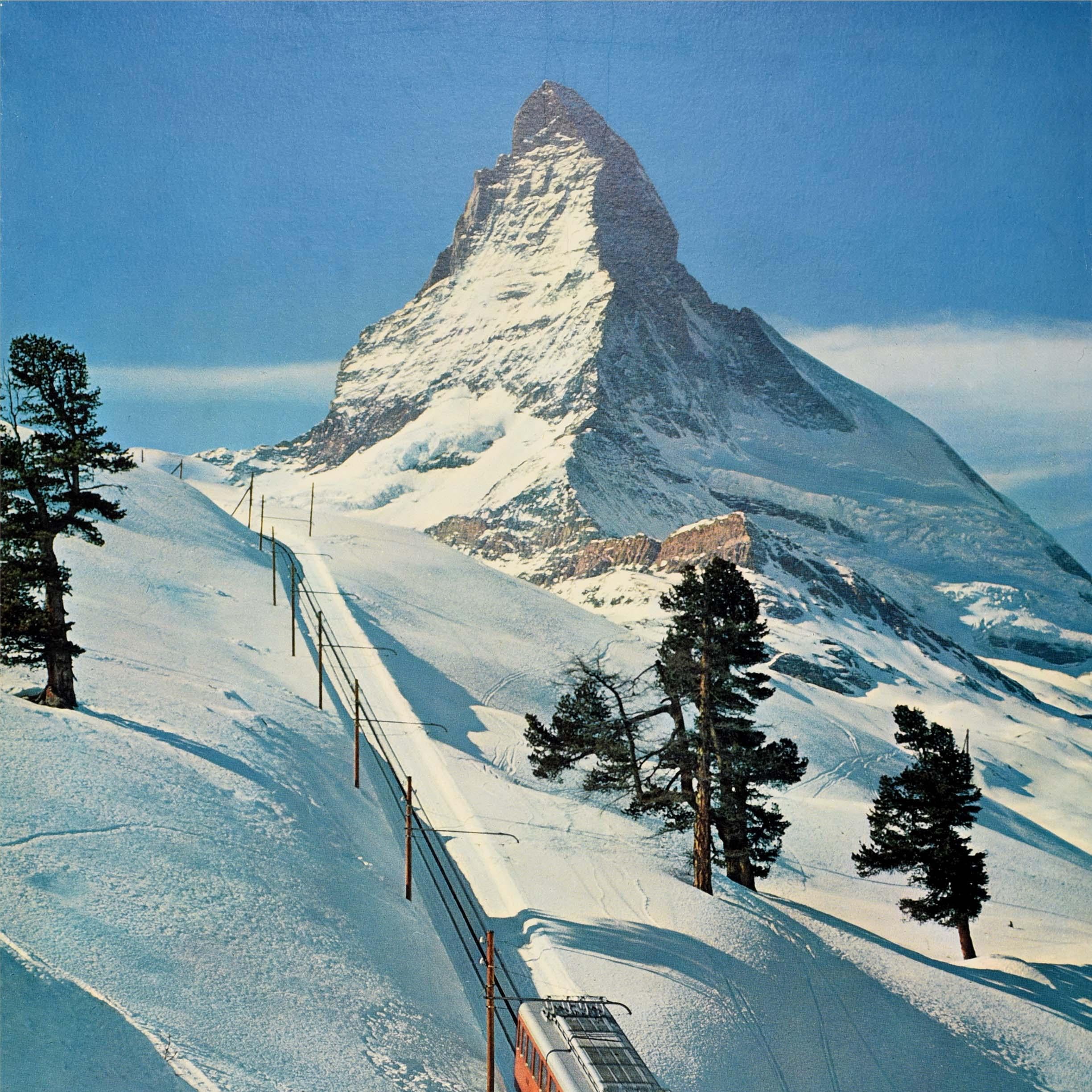 Poster originale d'epoca per lo sci e gli sport invernali della famosa località sciistica di Zermatt, in Svizzera, nel Canton Vallese, con il treno a cremagliera della Gornergrat Bahn e le piste da sci visibili sulla neve e la vetta del Cervino