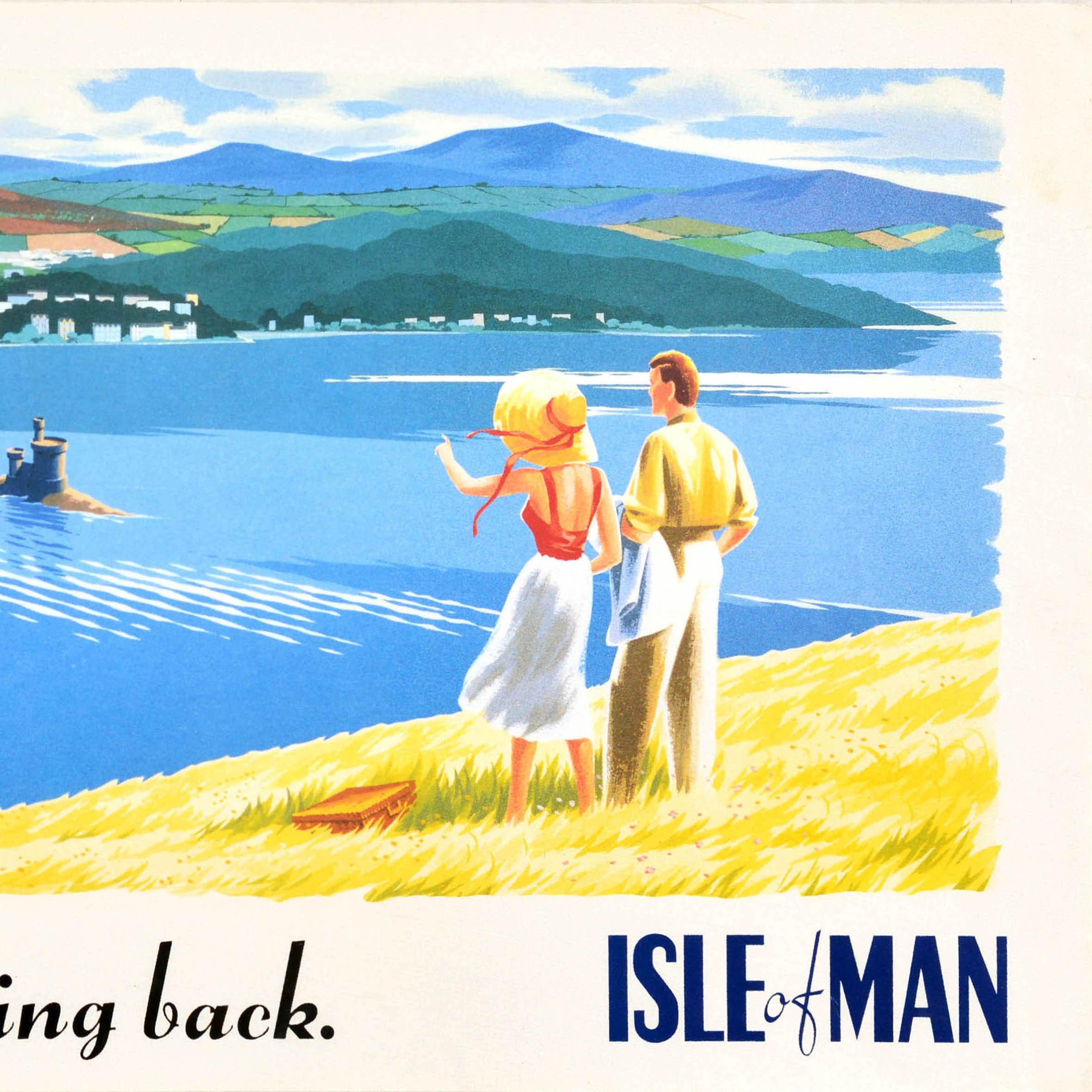 Original-Reisewerbeplakat für die Isle of Man mit einem großartigen Bild eines Paares, das die Aussicht von einem Hügel im Vordergrund betrachtet, mit einem Picknickkorb im Gras, der Mann hält seine Jacke über den Arm und die Dame mit Strohhut zeigt