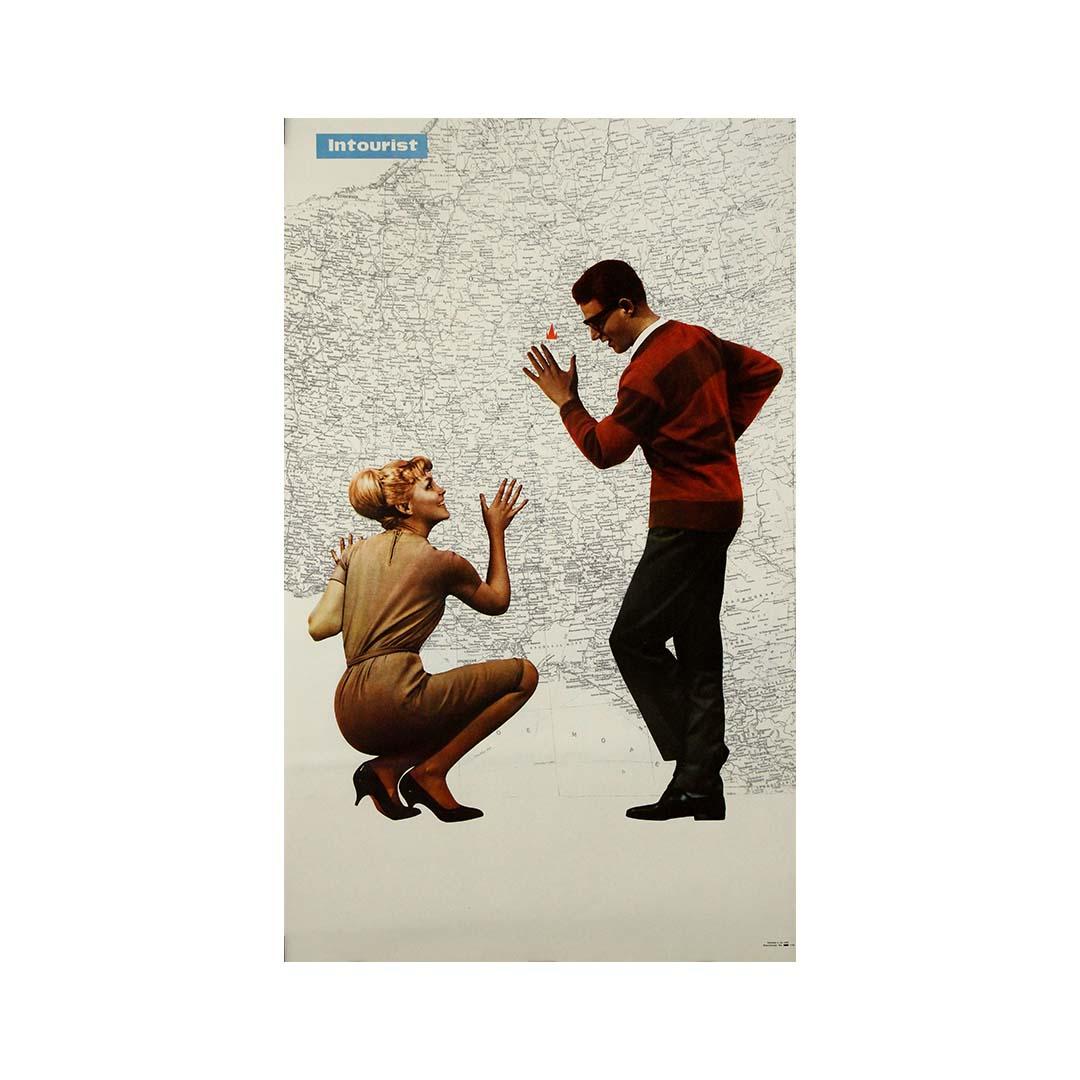 This striking 1970s original Soviet travel poster, produced by Intourist — the official state travel agency of the USSR — captures a moment of joyful anticipation and curious exploration. At the heart of the design is a playful interaction between a