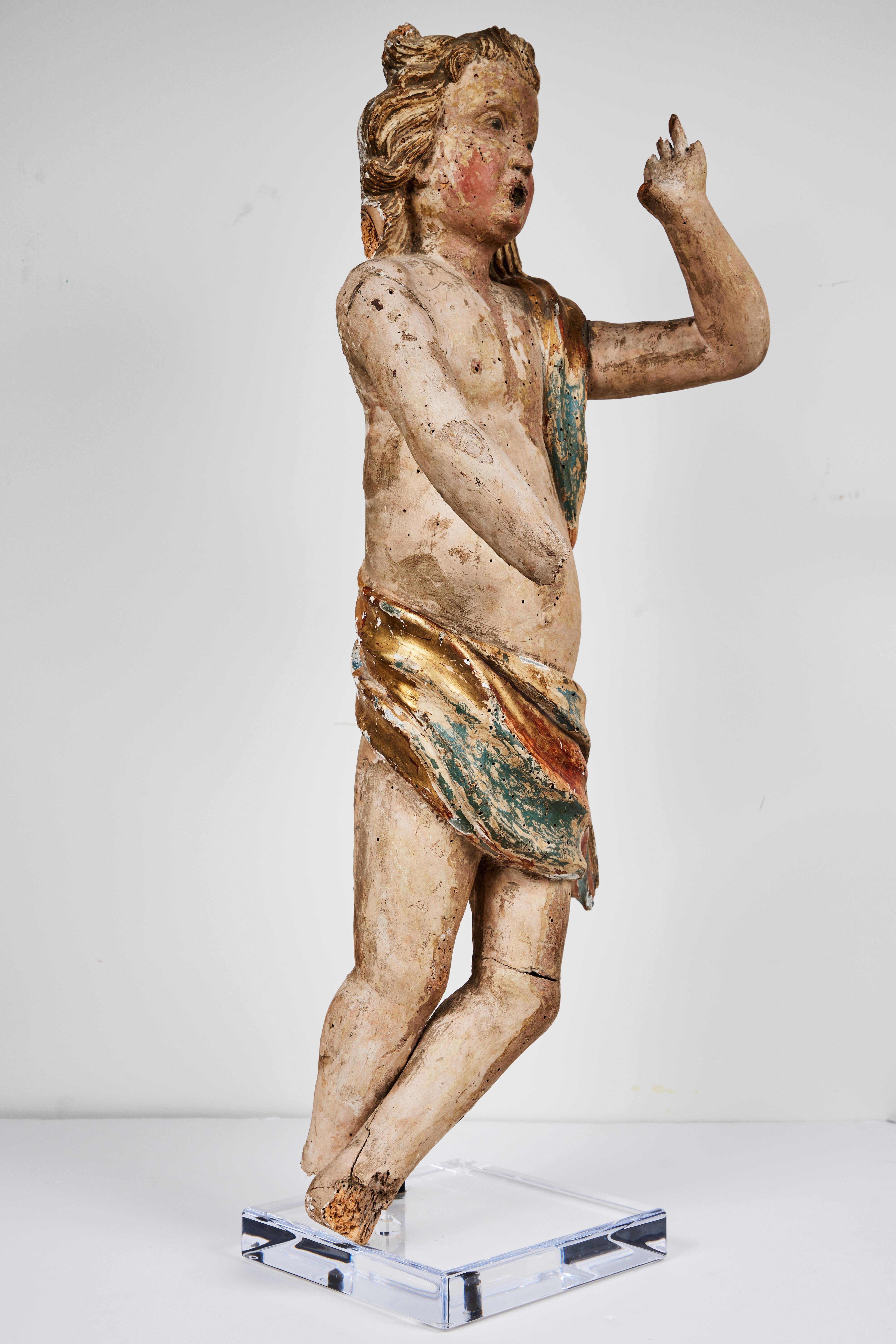 Eine ikonische, handgeschnitzte, gessoierte, bemalte und paketvergoldete italienische Polychromie-Skulptur eines zottelig gelockten Engels in windgepeitschtem Faltenwurf. Schöner Ausdruck und Patina. Jetzt auf einem speziell angefertigten