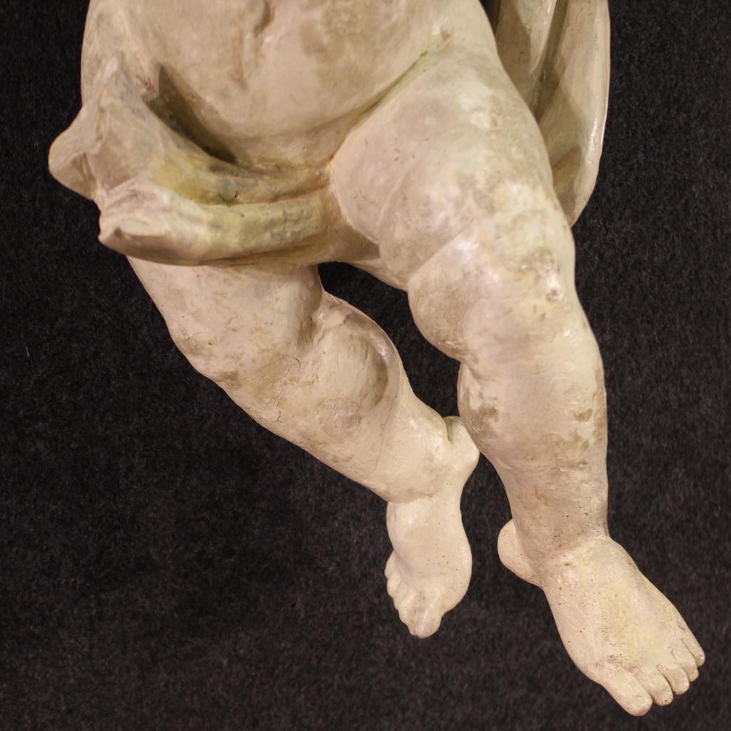 Escultura italiana del siglo XVIII. Obra de madera de gran tamaño e impacto, agradablemente tallada, que representa un gracioso querubín. Escultura pintada de color marfil (pintura no original, recuperada en el siglo XX) con bella decoración.