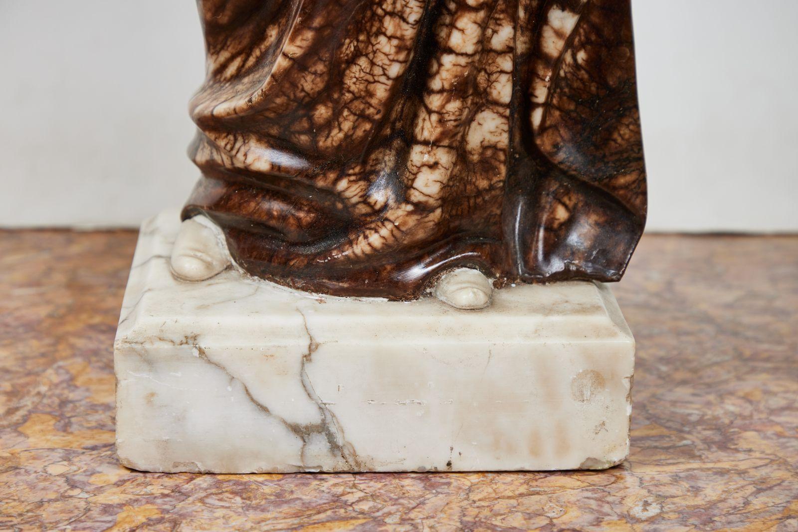 Sculpture antique en albâtre massif, délicatement sculptée, représentant le célèbre poète et philosophe italien Dante Aligheri (1265-1321). Le personnage, vêtu d'une riche robe fluide, tient un livre et porte un bonnet d'érudit couronné de lauriers.