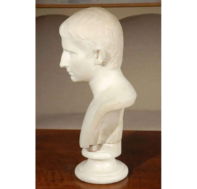 Français, buste en marbre d'un jeune Napoléon réalisé dans le style de César.  La tête repose sur la base détachée.
