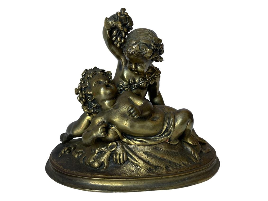 19th Century French Bacchanalian Bronze in the 18th century style depicting two Putti, in the manner of Clodion. One putto reclines while another feeds it grapes. The Patina is worn in places with rubbing and pitting, but overall it's an attractive
