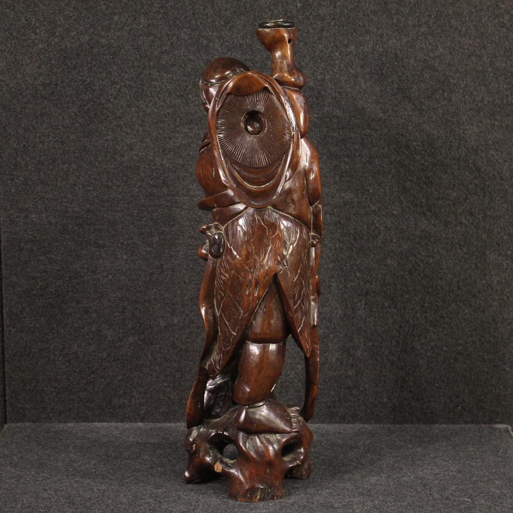 Escultura oriental de mediados del siglo XX. Objeto de madera exótica finamente tallado y elaborado que representa a un pescador con peces, de buena calidad. Escultura realizada a partir de un único bloque de madera, de buen tamaño, modificado