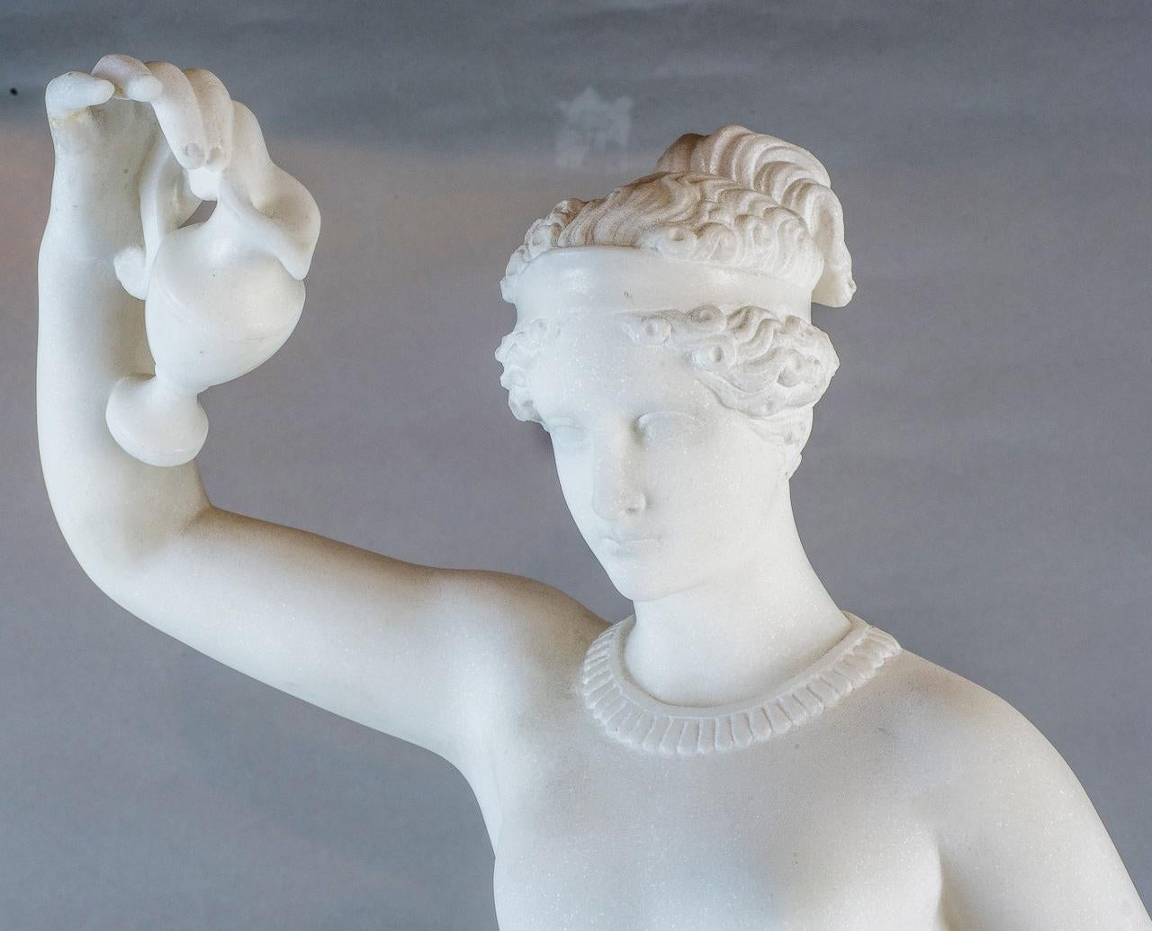 Marbre néoclassique finement sculpté d'une figure féminine debout portant une tasse et un pichet.  
Le marbre blanc cristallin crée des effets de lumière brillants. 

Origine : italienne
Date : circa 1890
Dimension : 27 1/4 po x 11 po x 12 po.