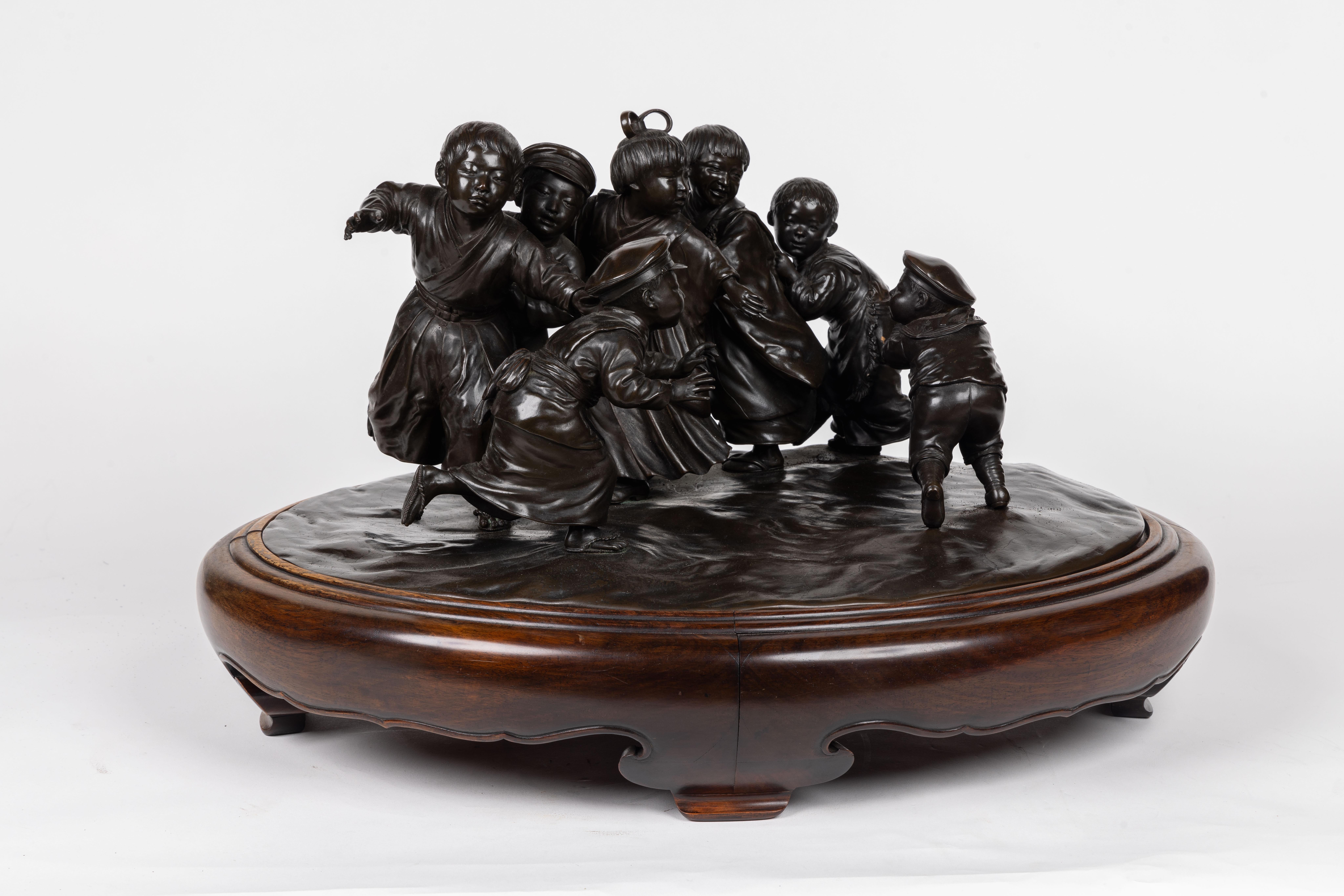 Presenting an extraordinary Large and Exceptional Japanese Meiji Period Tokyo School Bronze Sculpture depicting a delightful ensemble of six energetic boys engaged in a spirited pursuit of a single playful girl.
This magnificent sculpture