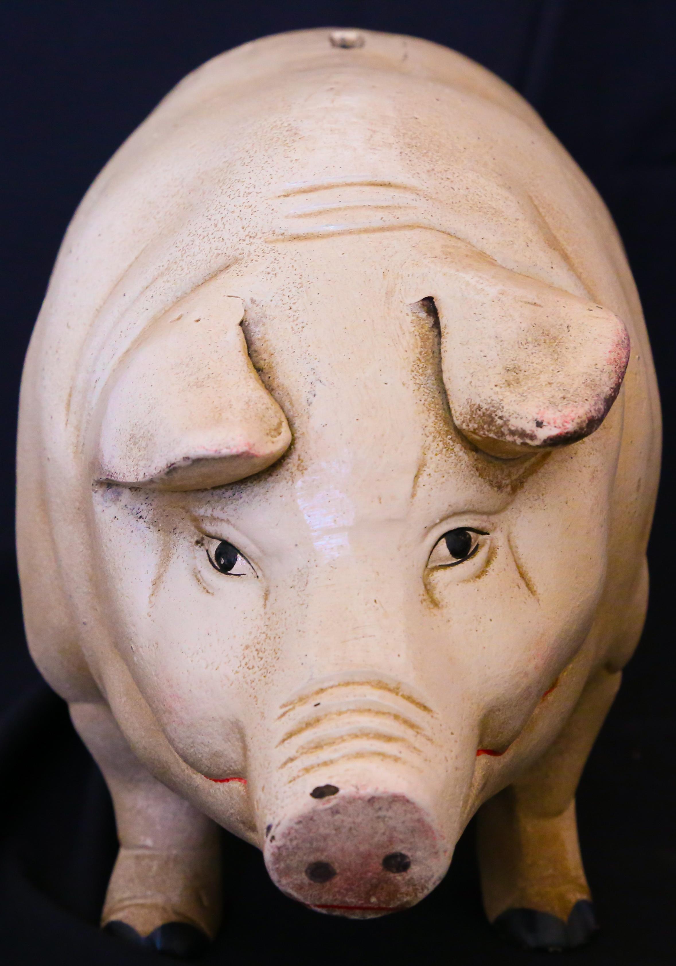 A piggybank, circa 1960s, cold-painted iron, with a coin-slot