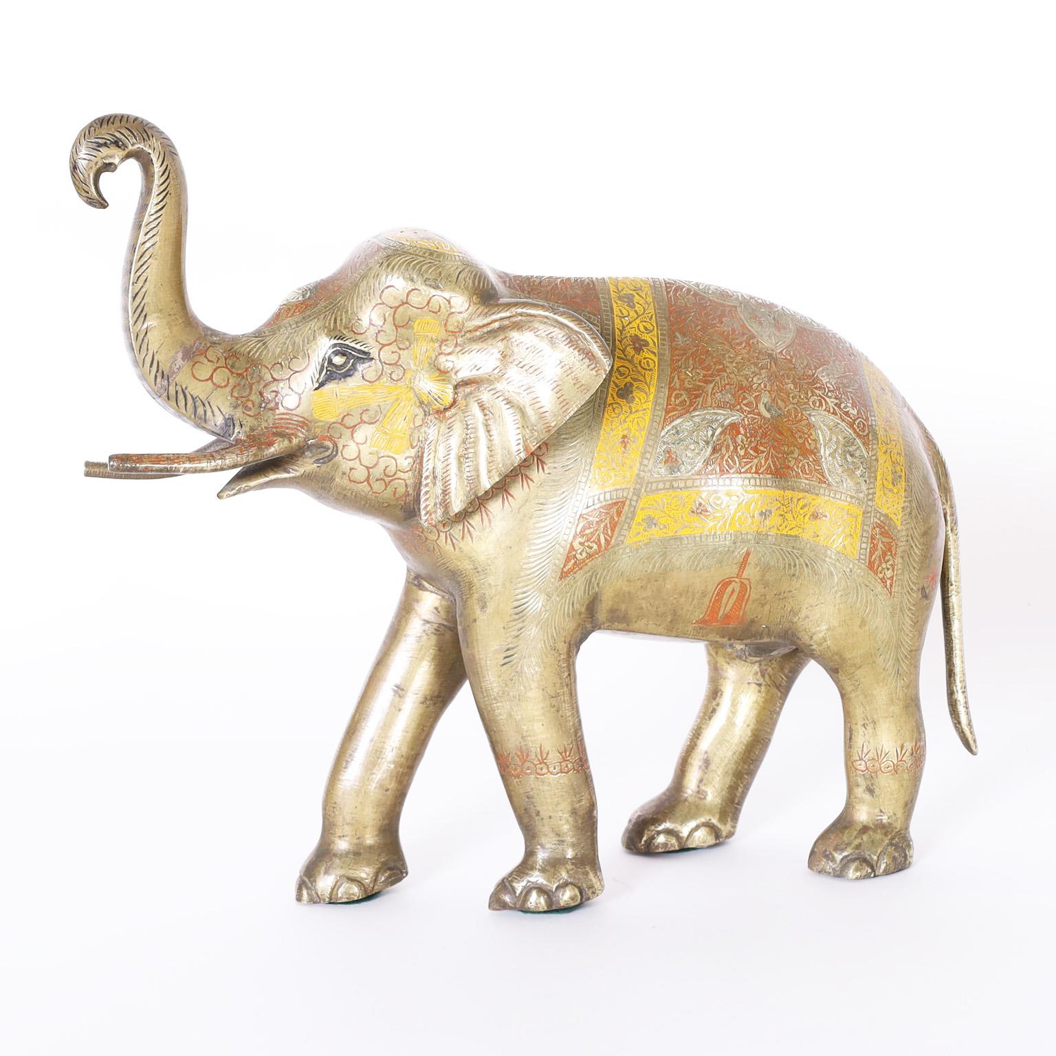 Elefante anglo-indiano in ottone fuso catturato a metà del montante e decorato con smalto rosso e giallo.