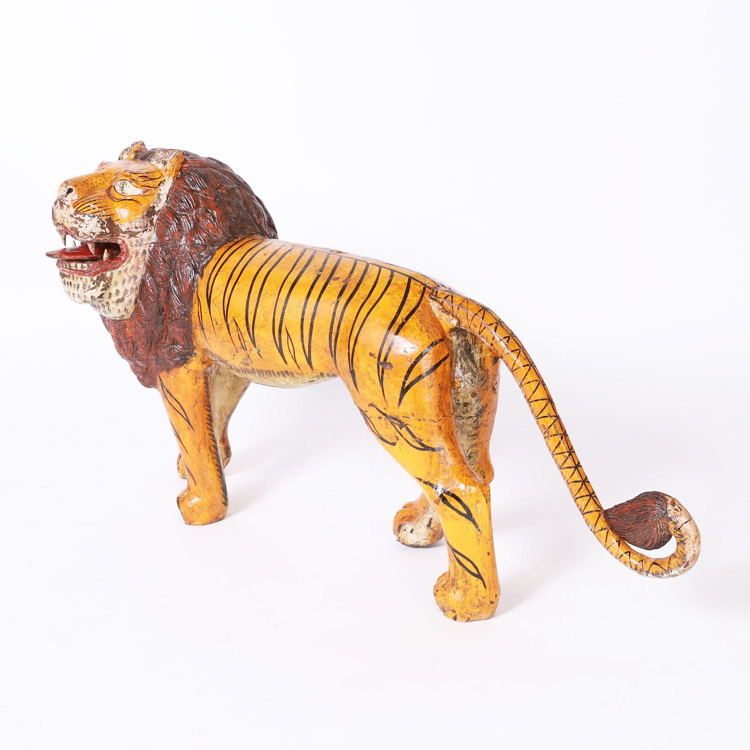 Sculpture rustique fantaisiste en acajou sculpté représentant un gros chat avec une combinaison surprenante mais charmante de la forme d'un lion et des rayures d'un tigre. Il a conservé sa peinture d'origine, aujourd'hui usée à la perfection.