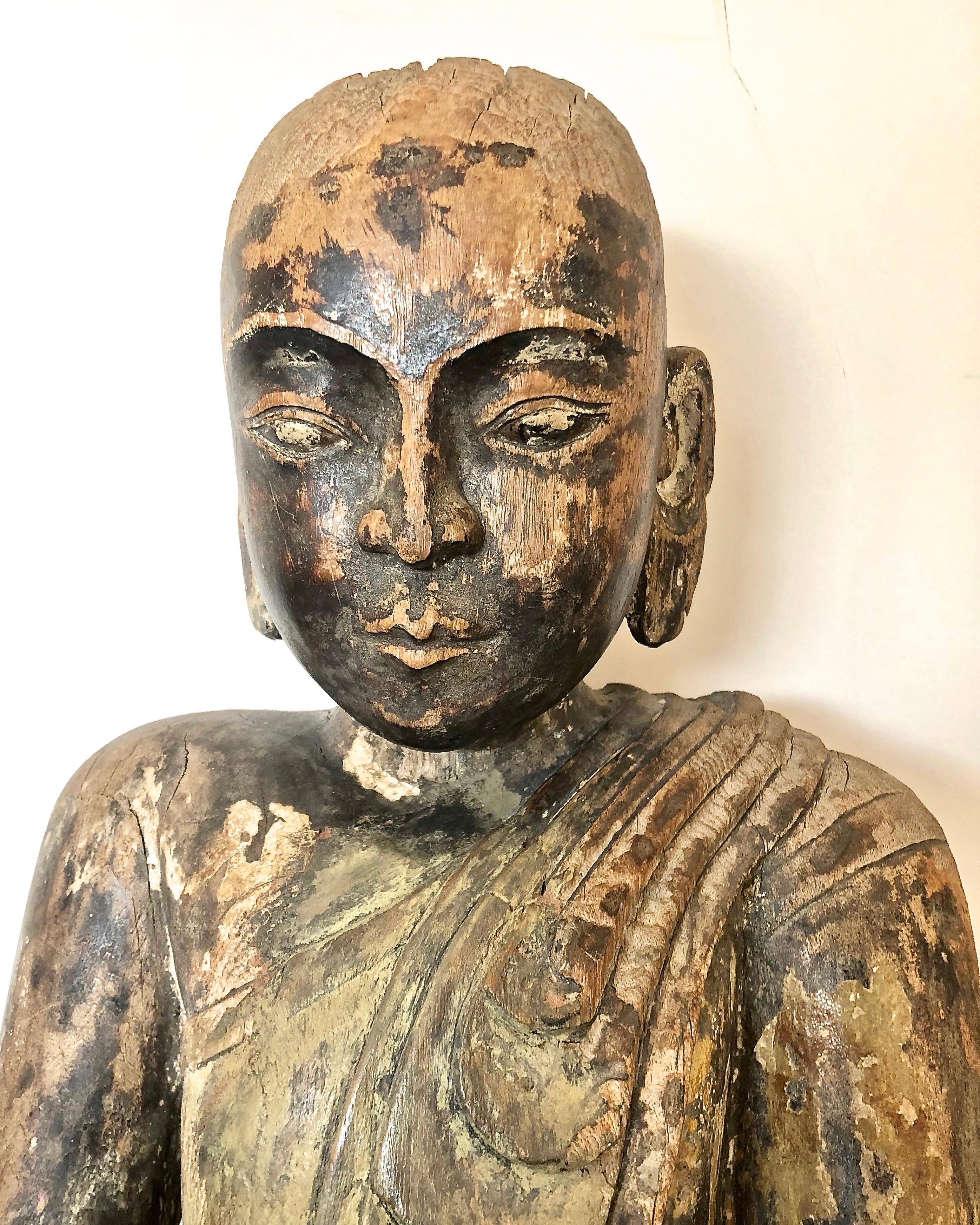 Antique Asian Wood Carving of a Buddhist Monk.
 Early 18Th Century or older possibly Burmese, Buddhist Monk resting on a lotus blossom on wood base, weather distressed, cracks, and loss of paint. 