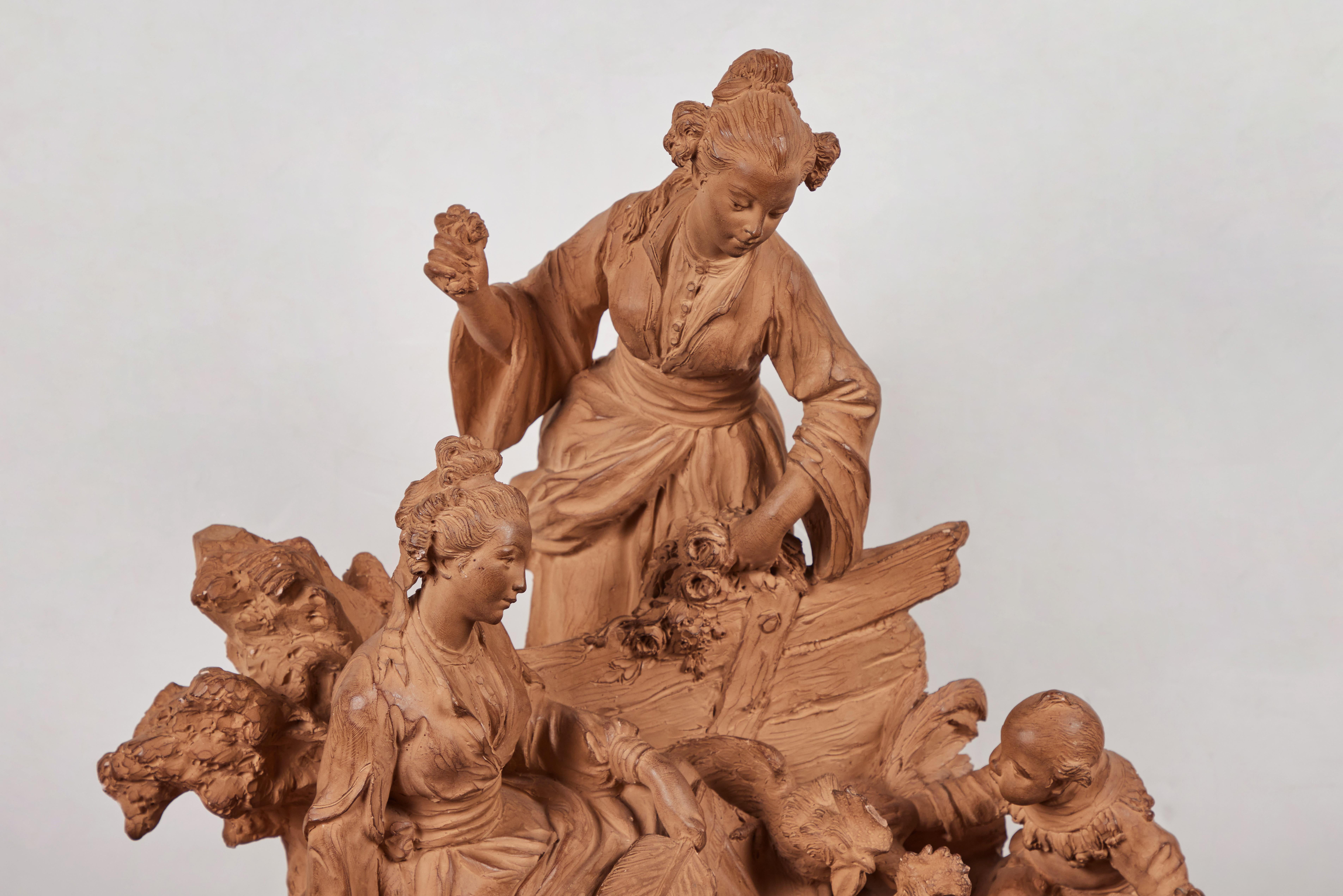 An elegant, dynamic, fully finished, 19th century terracotta sculpture of richly attired figures in the Chinoiserie style. The idealized, rural imagery features two women in flowing robes beside a fence; one seated on a tassled carpet, and another