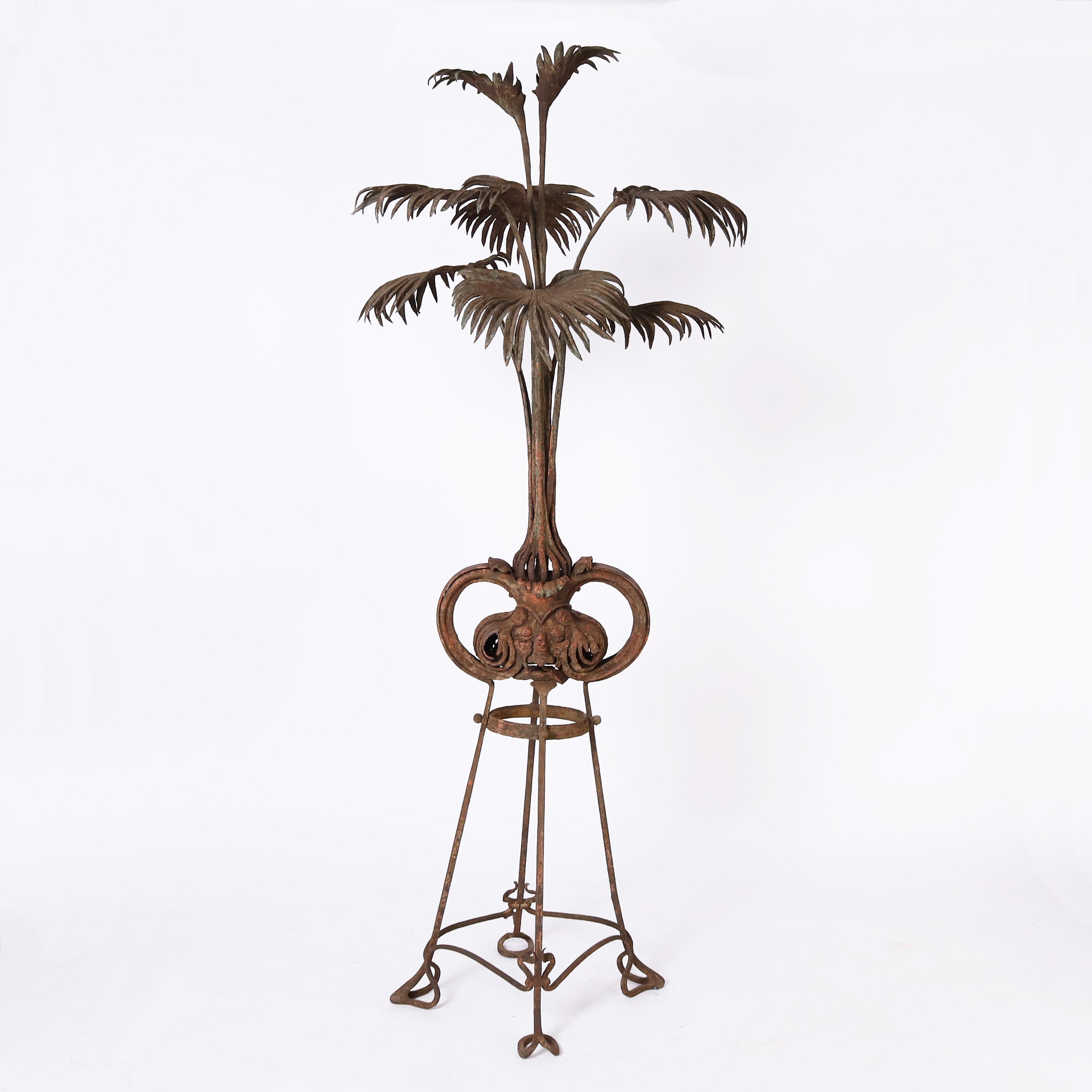 Standout 19th Century French La Belle Époque life size plant sculpture handcrafted in iron having a palm plant on a distinctive Art Nouveau style wrought iron base, all with a time earned oxidized finish. 