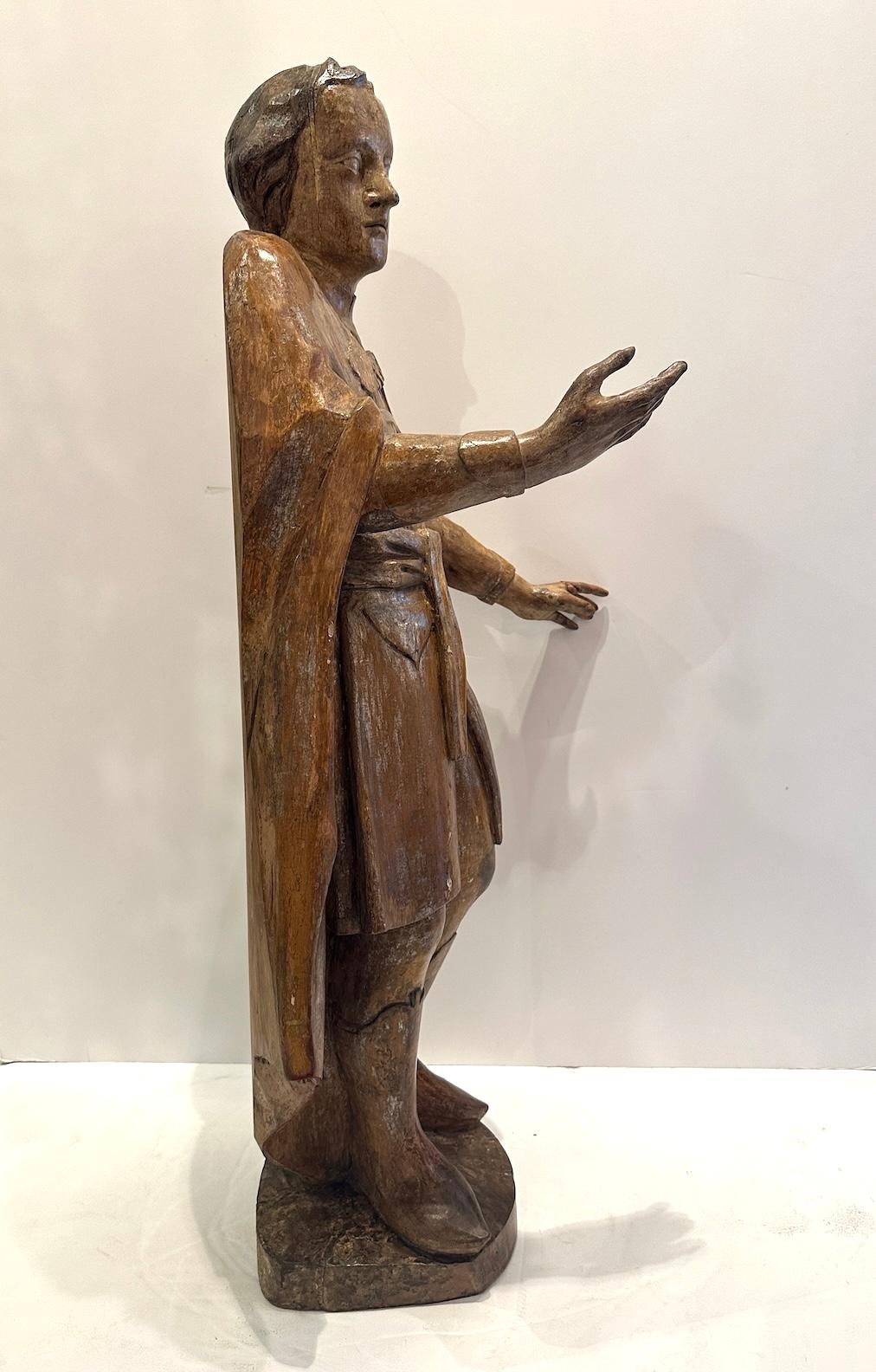 Antica statua di uomo scolpita a mano con tracce di doratura in argento.