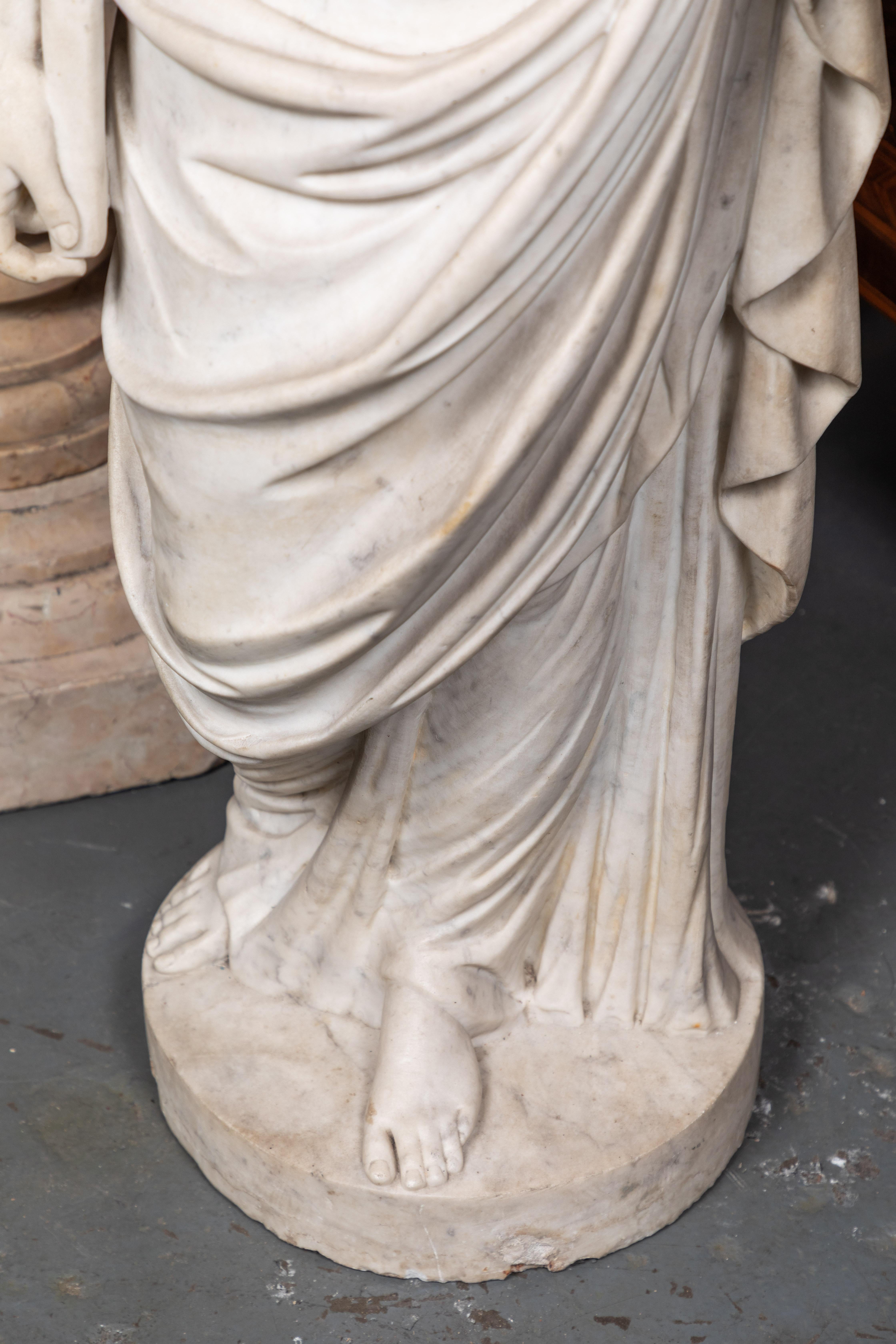 Stunningly hand carved, large, circa 1825, solid Carrara marble statue of the crowned, Roman goddess, Juno- known in ancient times as the ruler of marriage, home, and family, a champion of women, and protector of the Roman state.