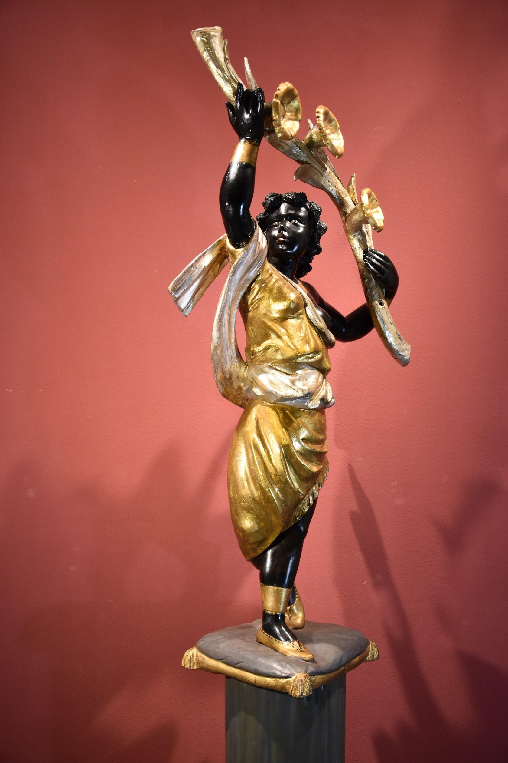 Antique sculpture of a female Moor with flowering cornucopia
Venice, 19th century
Carved, lacquered and gilded/silvered wood

Total height 202 cm (column base 82 cm, figure 120 cm)

This is a qualitative wooden sculpture depicting a Moor with a