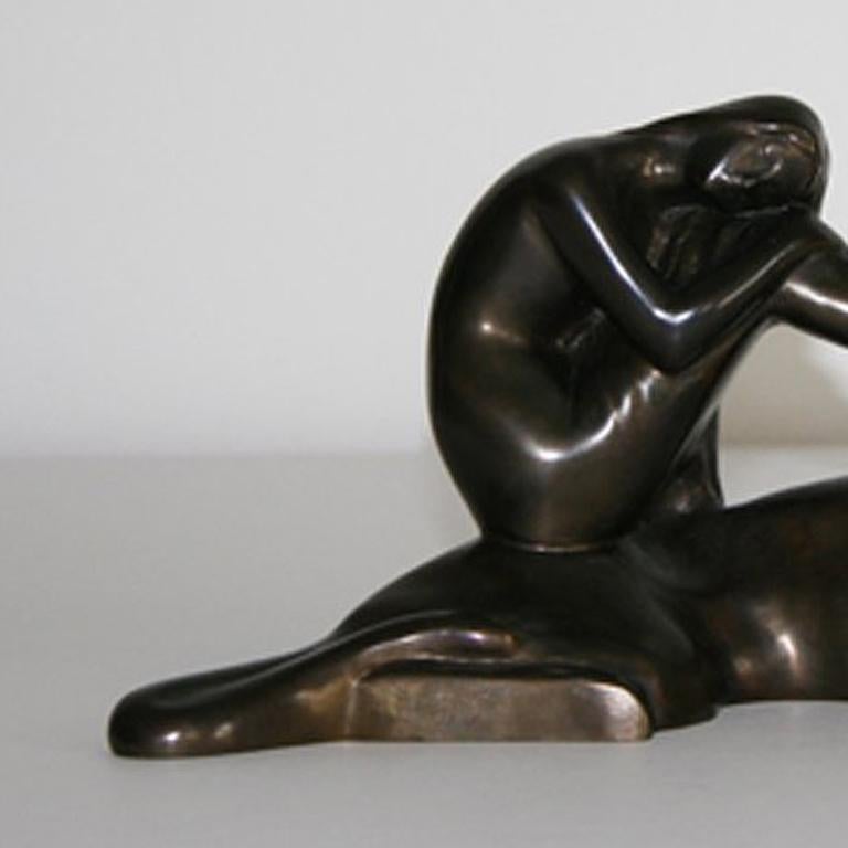 This Art Déco bronze with a dark patina shows a nude Ariadne with long hair, sitting on a lying panther.