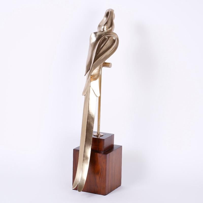 Impressionante scultura di pappagallo Macaw in ottone fuso realizzata nel Mid-Century con influenza Art Deco. Ha una forma leggiadra e fluente ed è presentato su un supporto in noce. Lucidato e laccato a mano per una facile manutenzione.