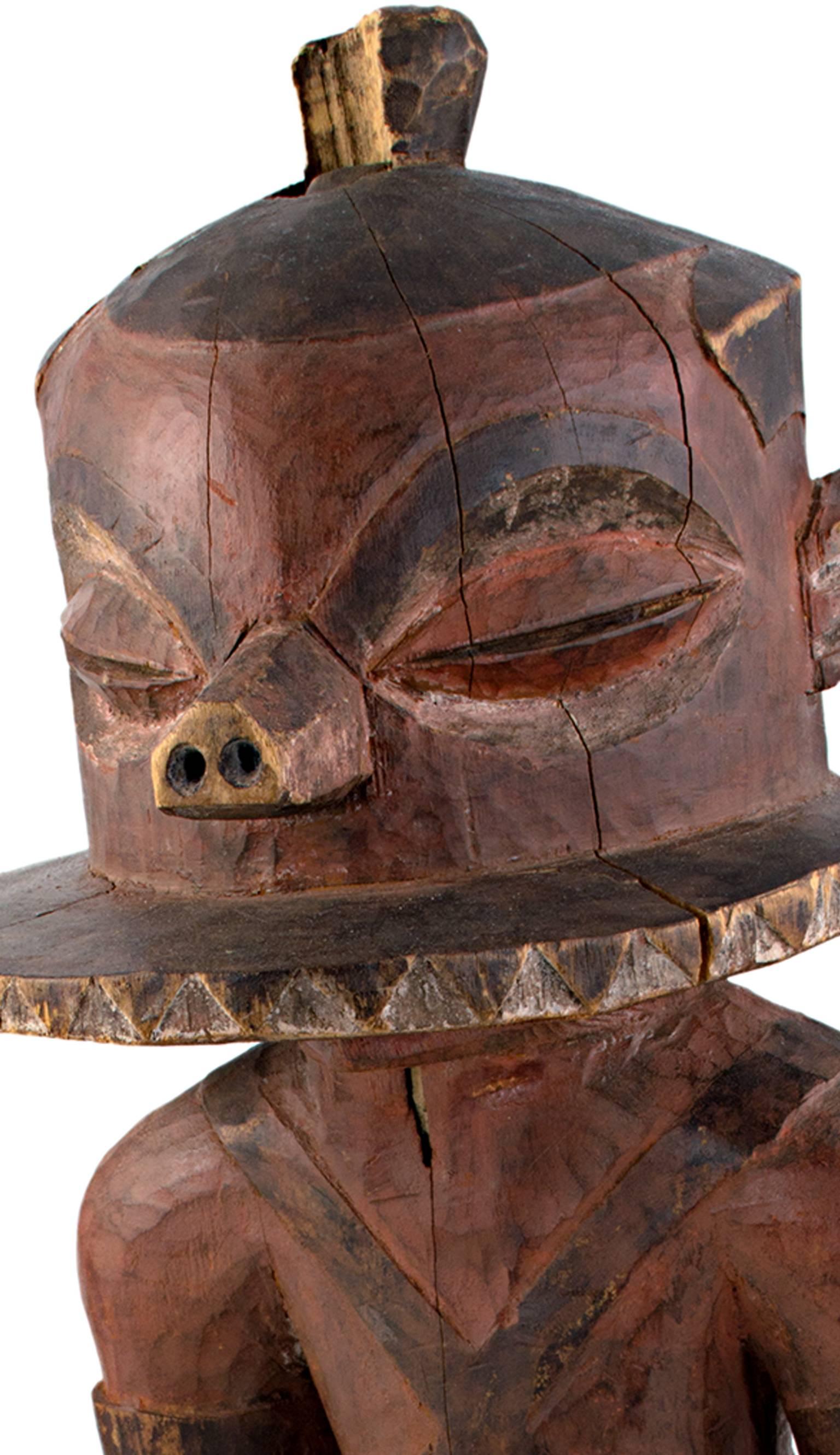 Diese Statue wurde von einem unbekannten Pende-Künstler aus Zaire geschnitzt. Es zeigt einen gehenden Mann mit einer Scheibe auf dem Kopf und großen Augen. 

25 3/4