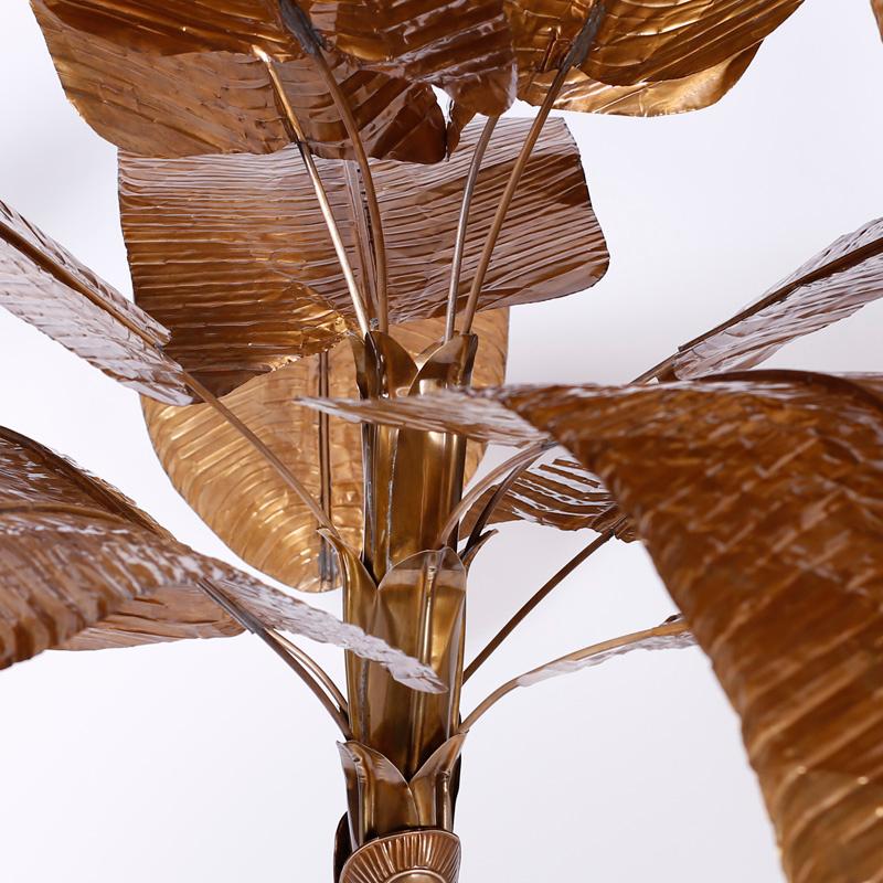 Brass banana tree or palm tree sculpture with a custom burnished bronze like finish, removable leaves, a weighted base decorated with floral designs, and lacquered for easy care.