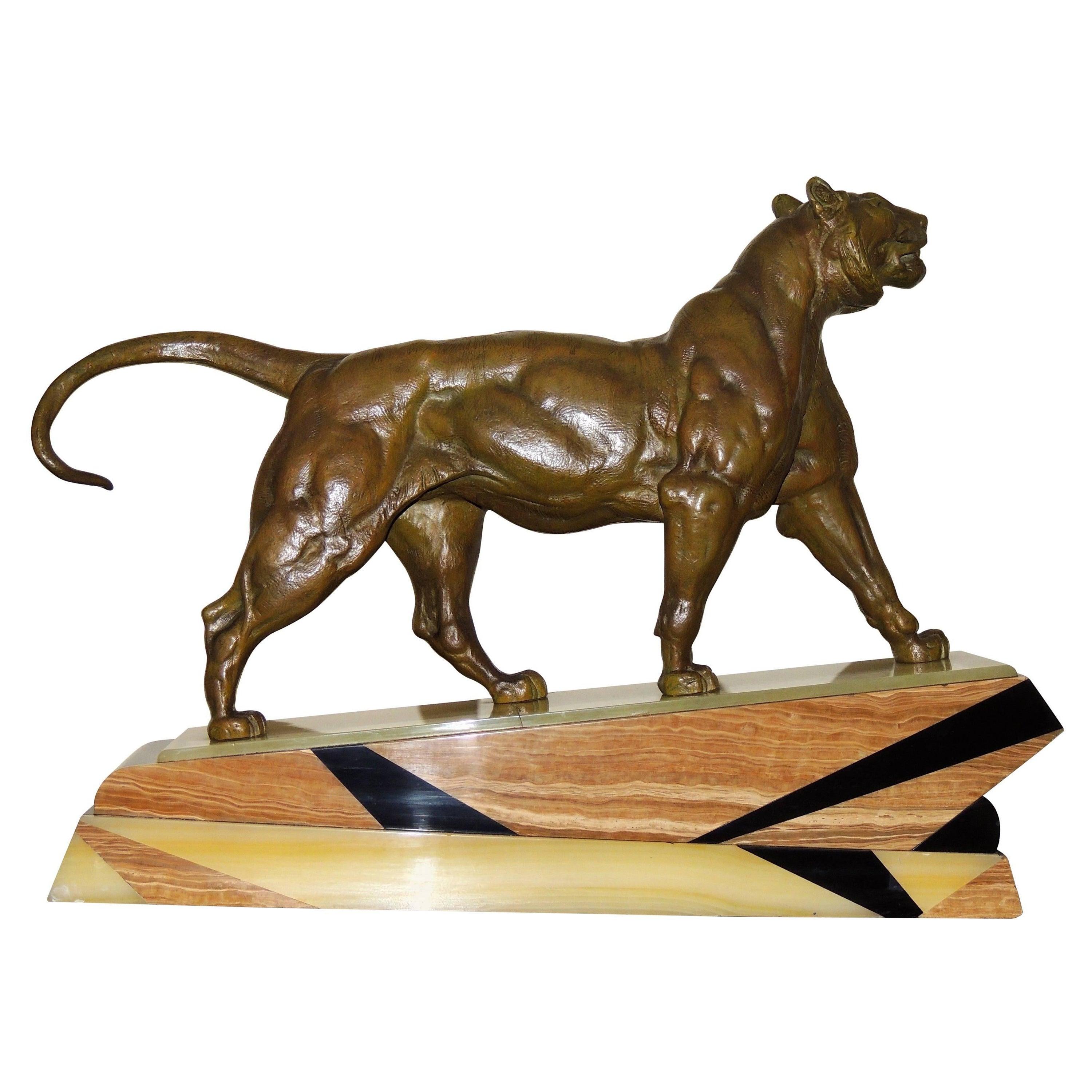 This is an Art Deco bronze statue of a lion with a great marble base of three tones inlaid in geometric shapes. The lion is powerfully rendered, and its expression and musculature are well-defined.

Throughout history, the Lion has been known as the