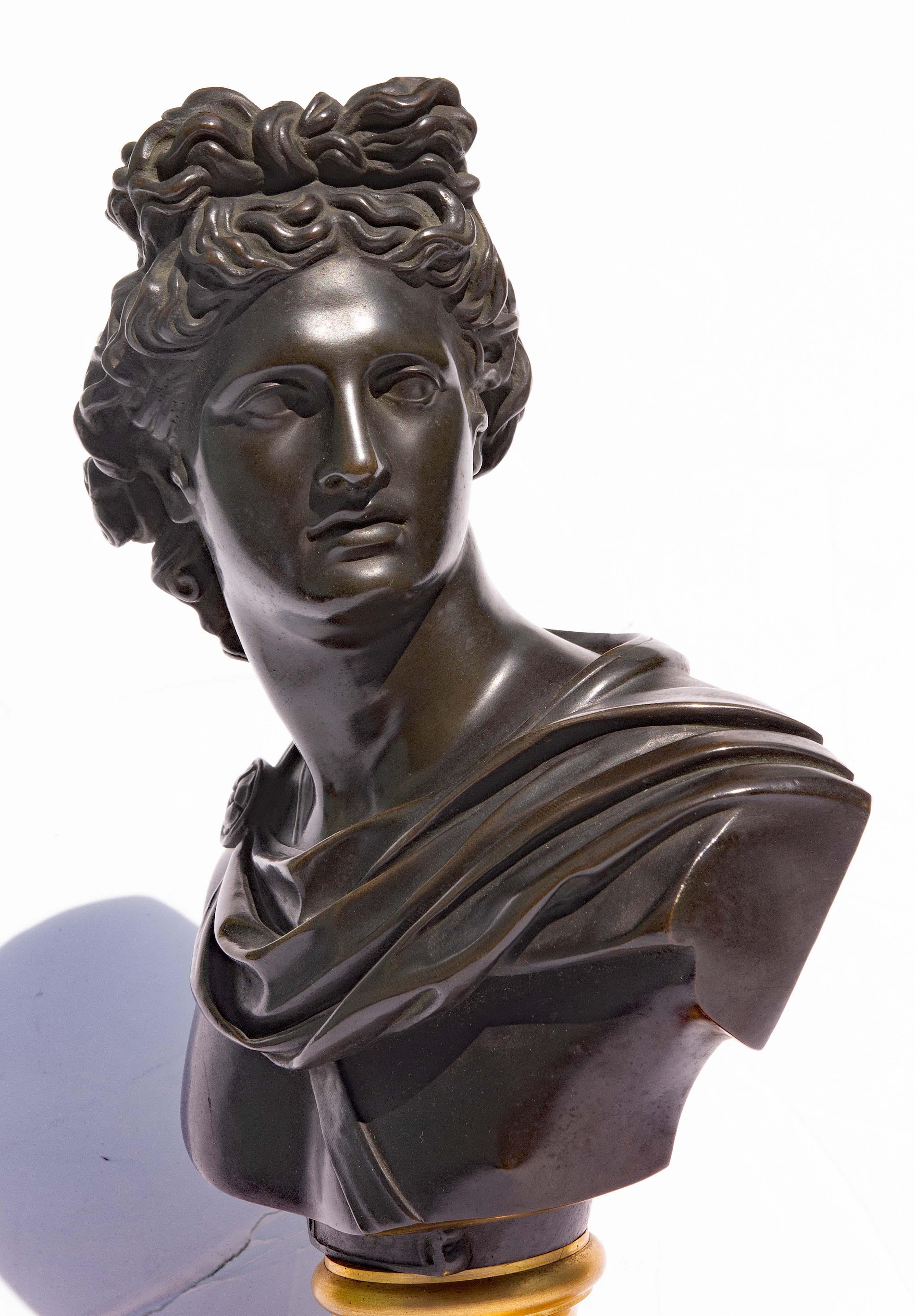 Magnífico busto de bronce y bronce dorado del siglo XIX del dios Apolo Belvedere. Circa 1850. Este maravilloso busto de gran viaje es una maravilla de refinada belleza y elegancia, elaborado con bronce ricamente patinado sobre un zócalo de bronce