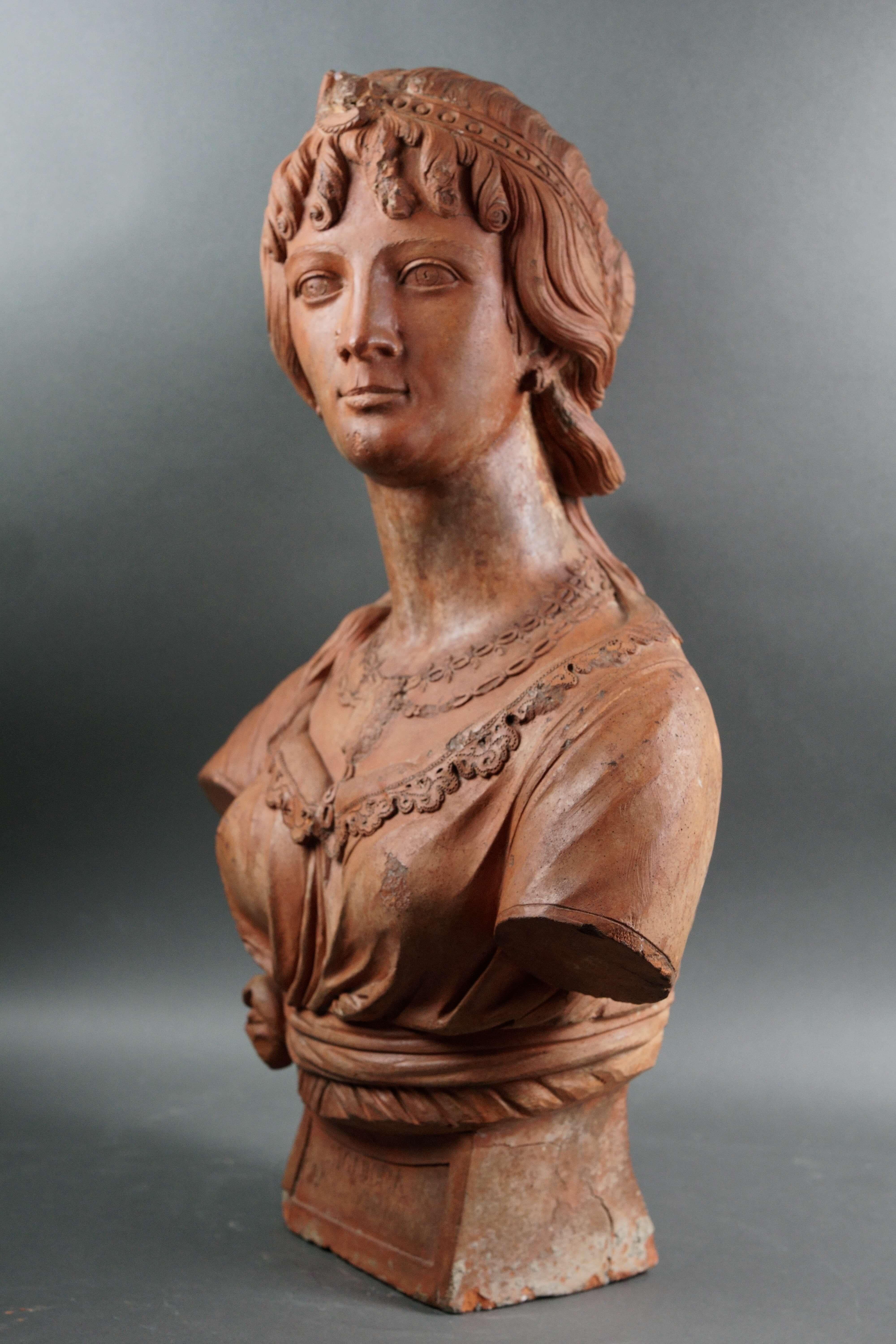 Busto de terracota, retrato de una joven dama, Italia, Toscana, segunda mitad del siglo XVIII.  
El busto, enteramente moldeado a mano, representa a una joven con un complejo peinado que lleva al cuello un medallón con el rostro de su amado.  El